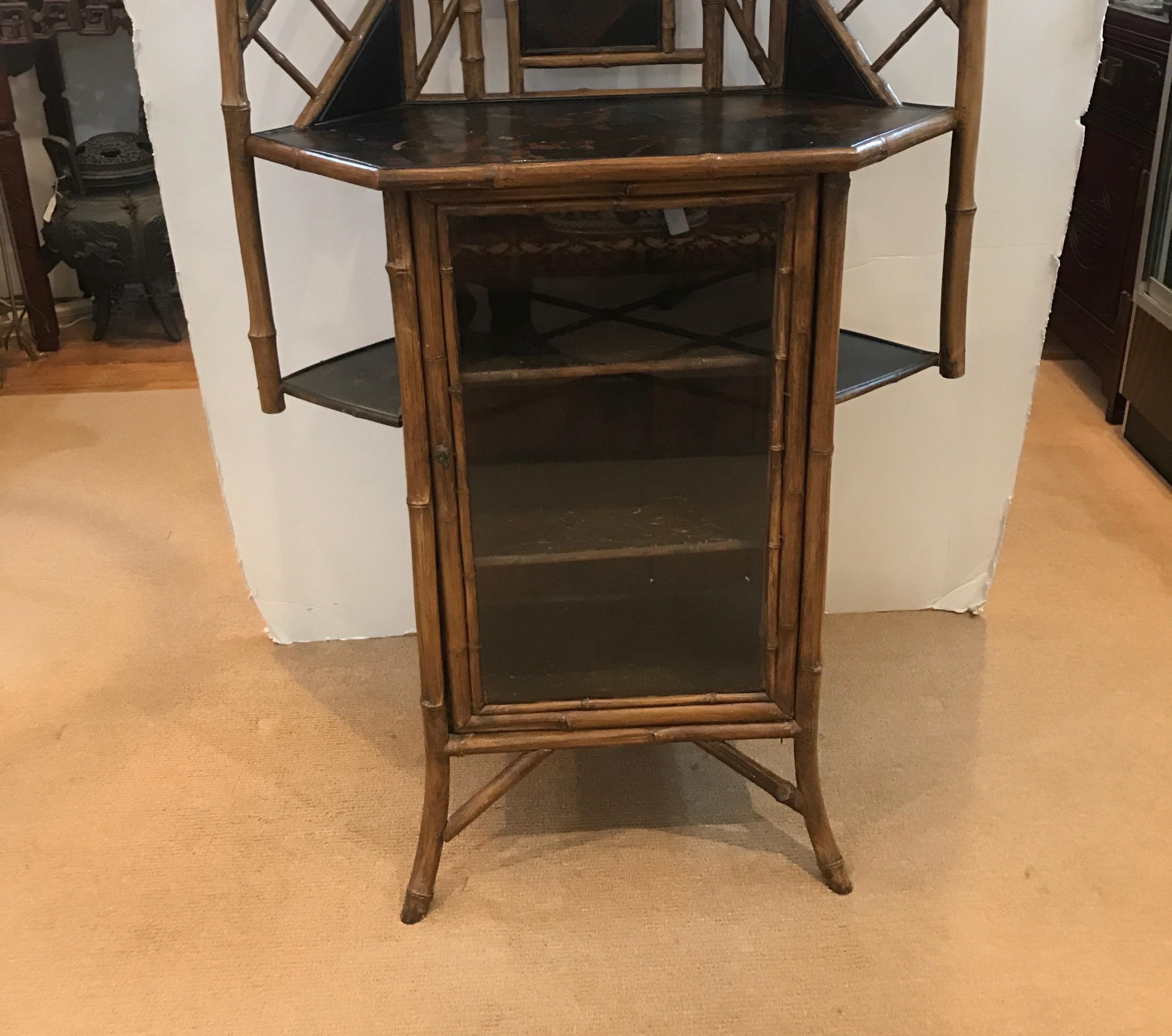 A pagoda top French lacquer and bamboo corner cabinet with lower glass door and upper beveled mirror. The black lacquer with Asian inspired decoration with a pagoda shaped top.


 