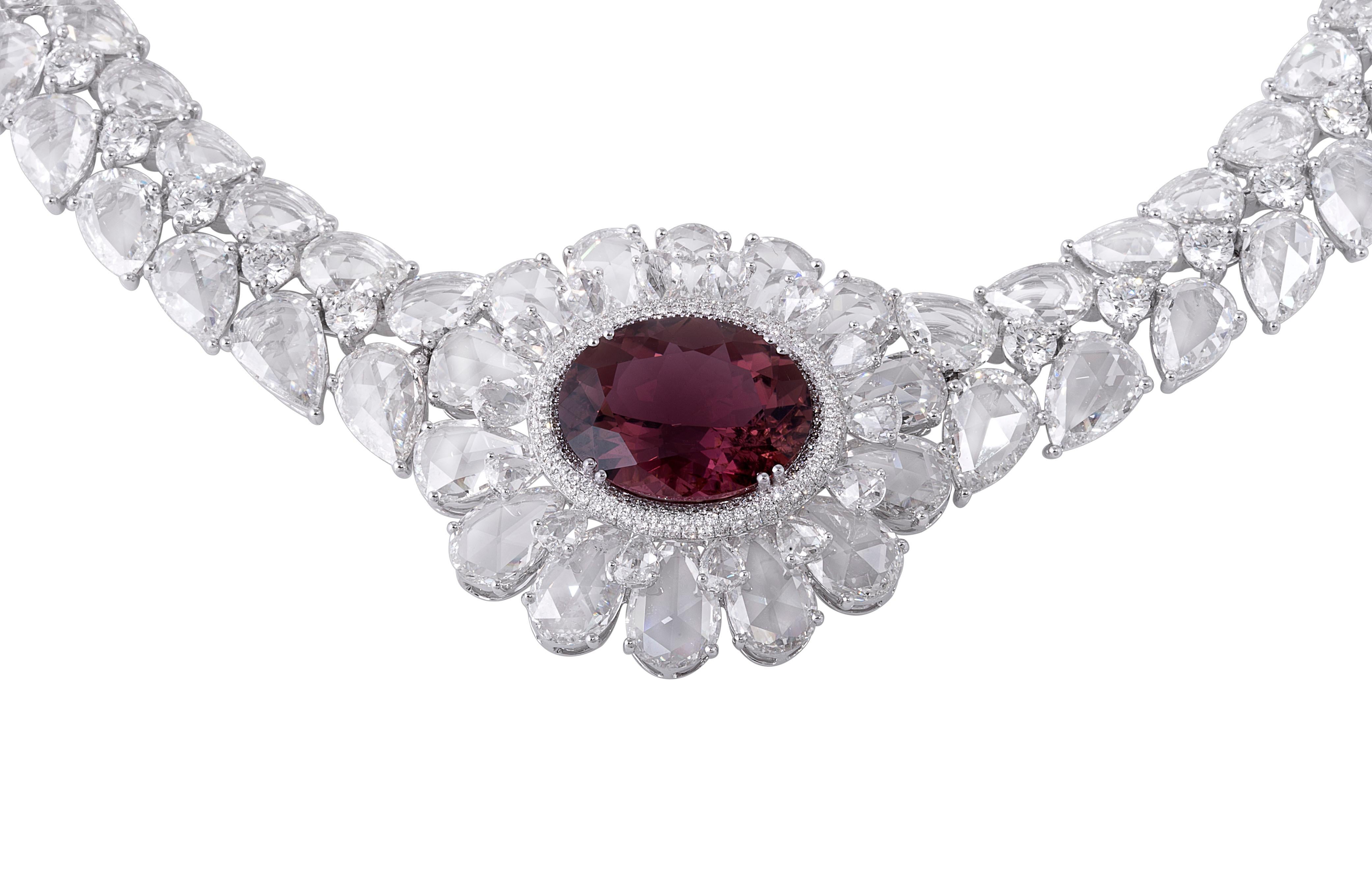 Enveloped in pear-shaped rose cut diamonds, sits a 9.08ct deep, red-hued rubellite, forming one of the most iconic pieces crafted by Rarever. 
A belt full of rose and brilliant-cut diamonds follow the central floral motif. This 18-karat gold
