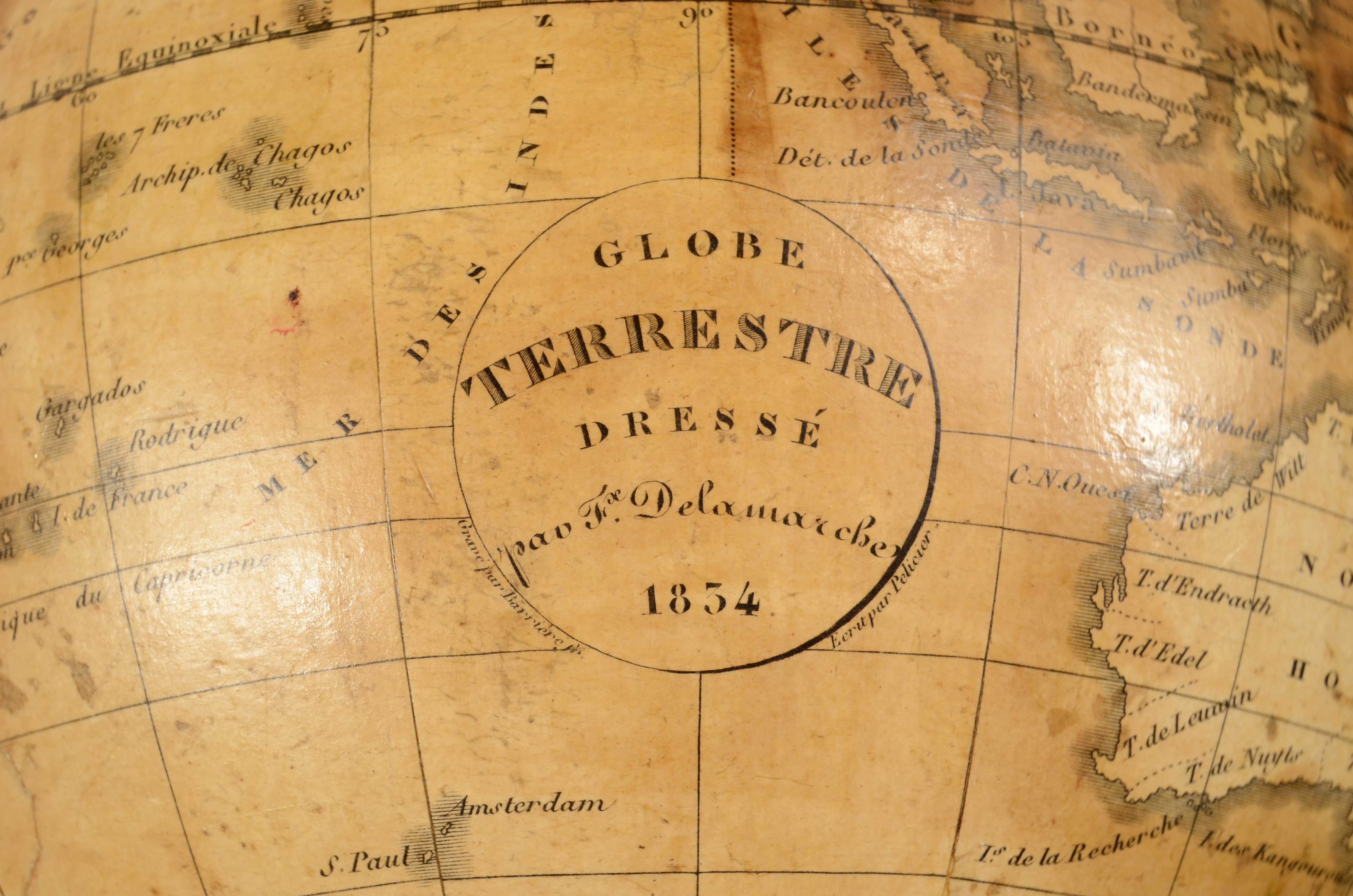 Rare paire de globes terrestres et célestes réalisés par Felix  Delamarche en 1834. Le cartouche du globe indique Globe Terrestre Dressé par Felix Delamarche 1834. Boules en plâtre et papier mâché, bases de panier en bois tourné et ébonisé, avec