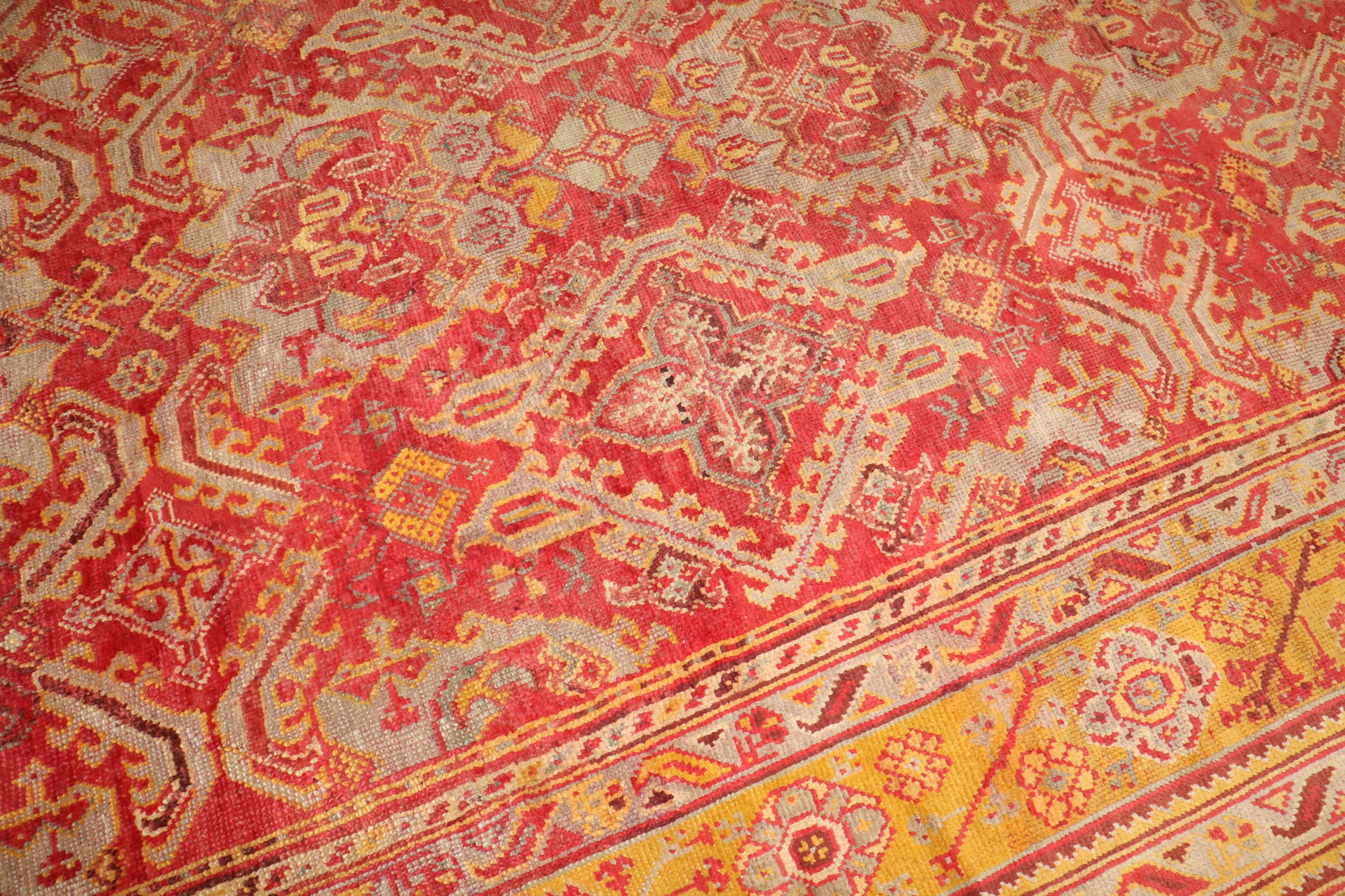 A colorful early 20th century antique Turkish Oushak rug. Predominantly Raspberry and mustard.

Measures: 12'2