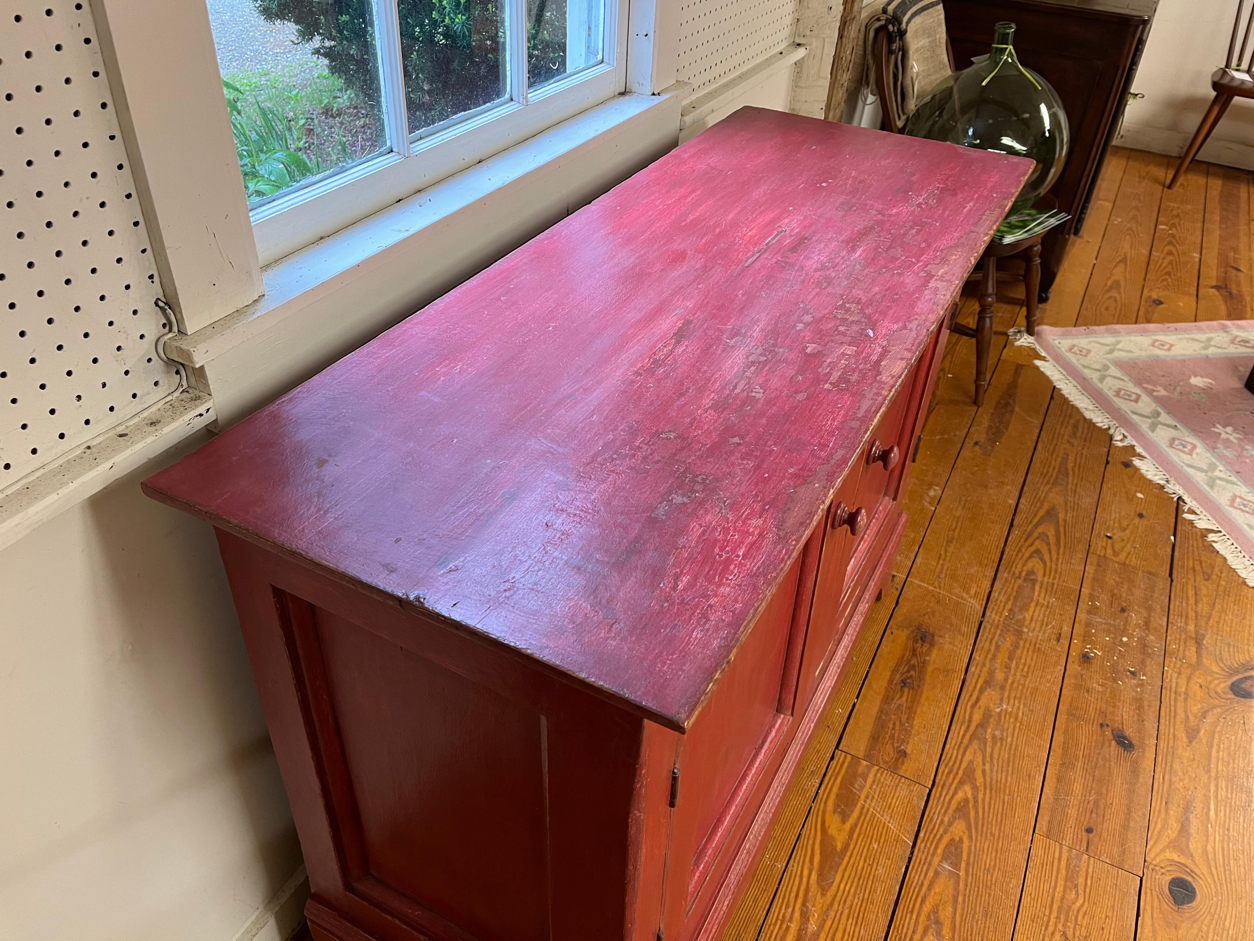 the Canadians have very interesting colors on their painted furniture and this 2 door buffet is a perfect example. this raspberry buffet has original hardware and original shelves and plenty of storage.