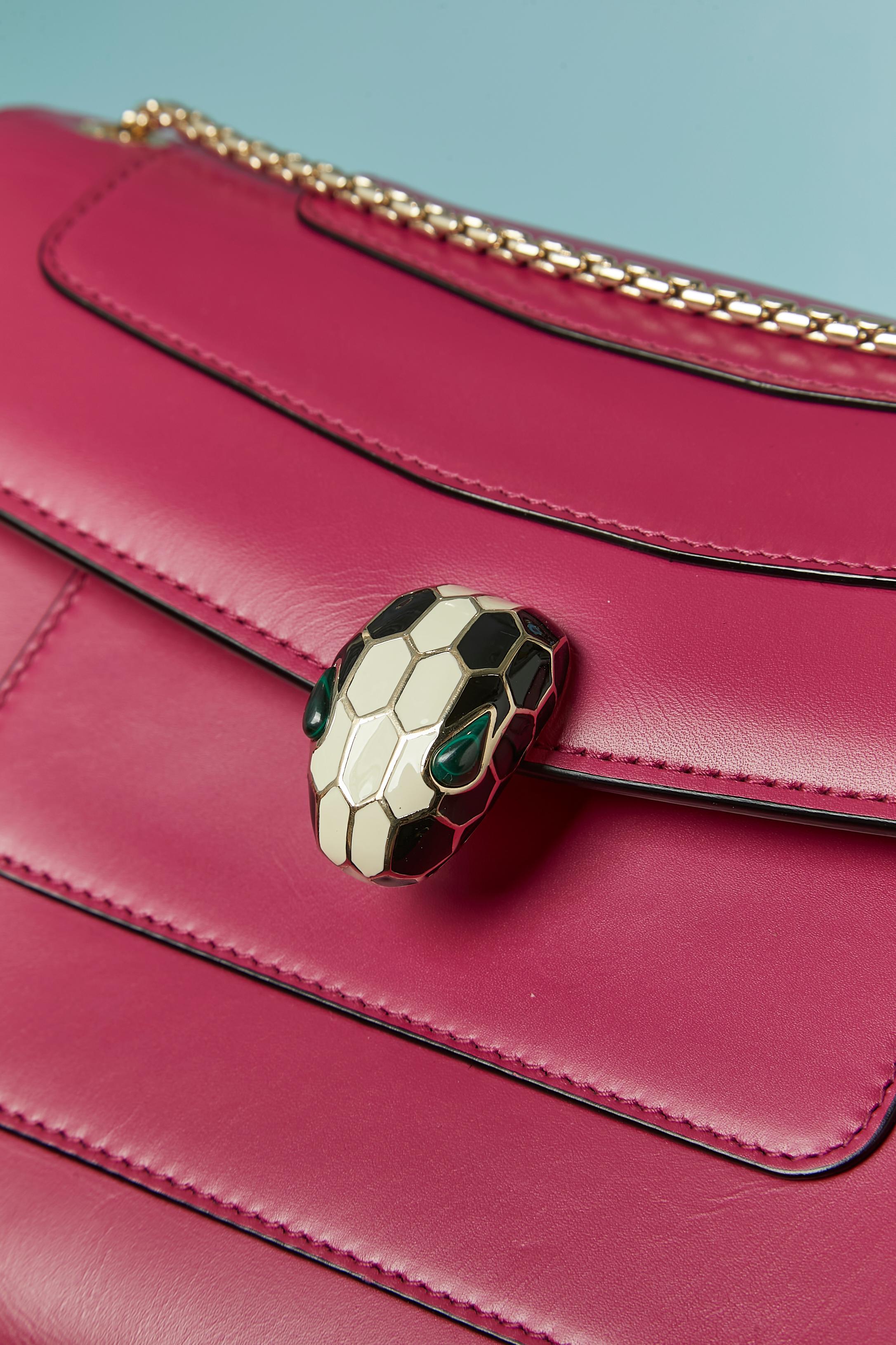 Raspberry pink shoulder bag with snake head closure. Purple rayon lining. Snap closure under the snake. 2 compartiments inside + one with zip closure. 2 pockets inside ( 1 flat pocket with mirror and 1 flat pocket ) 
Authenticity hologram. Dust-bag