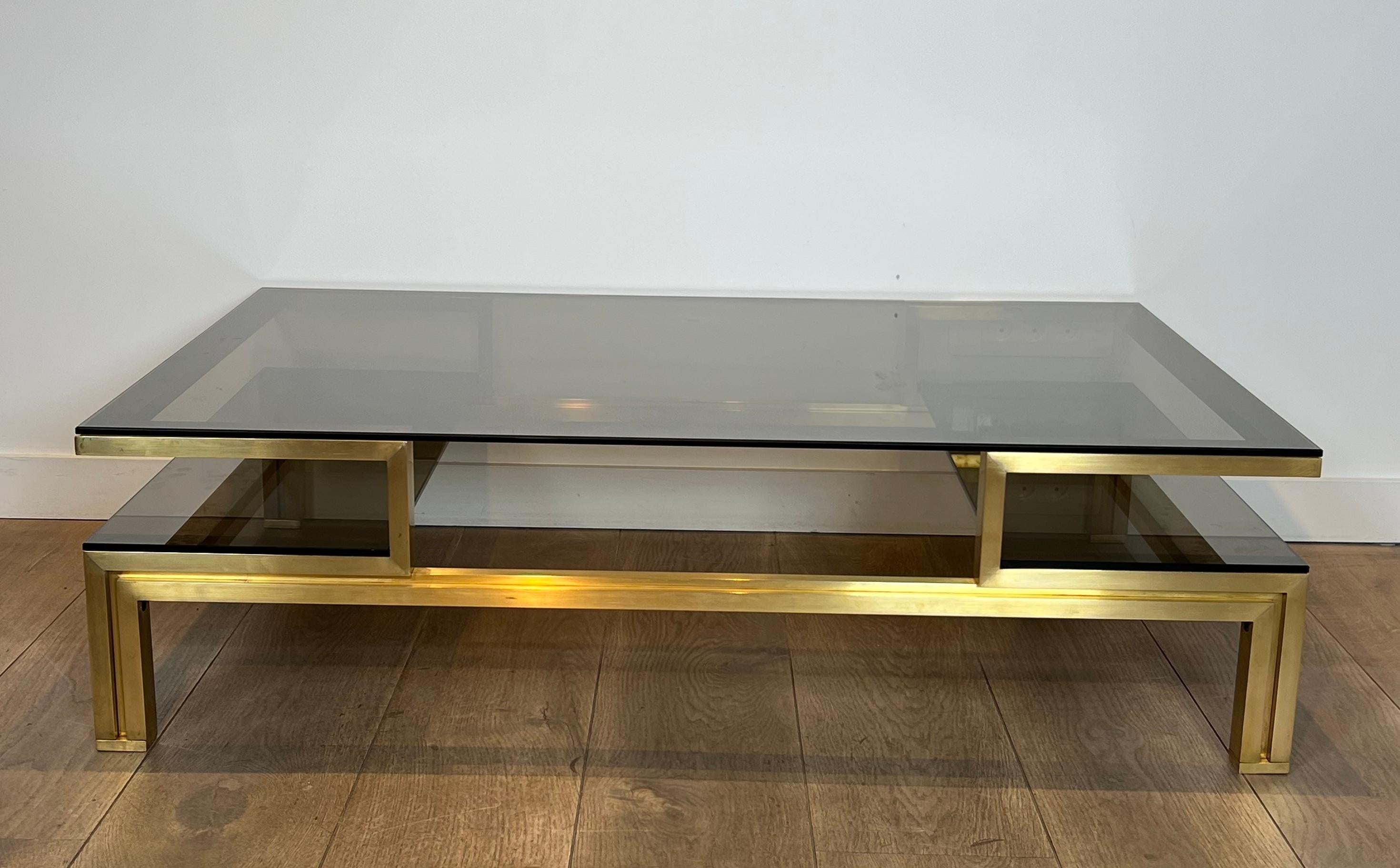 This very nice modernist coffee table is made of brass with smoked glass shelves. This is a French work by famous designer Guy Lefèvre for Maison Jansen. Circa 1970