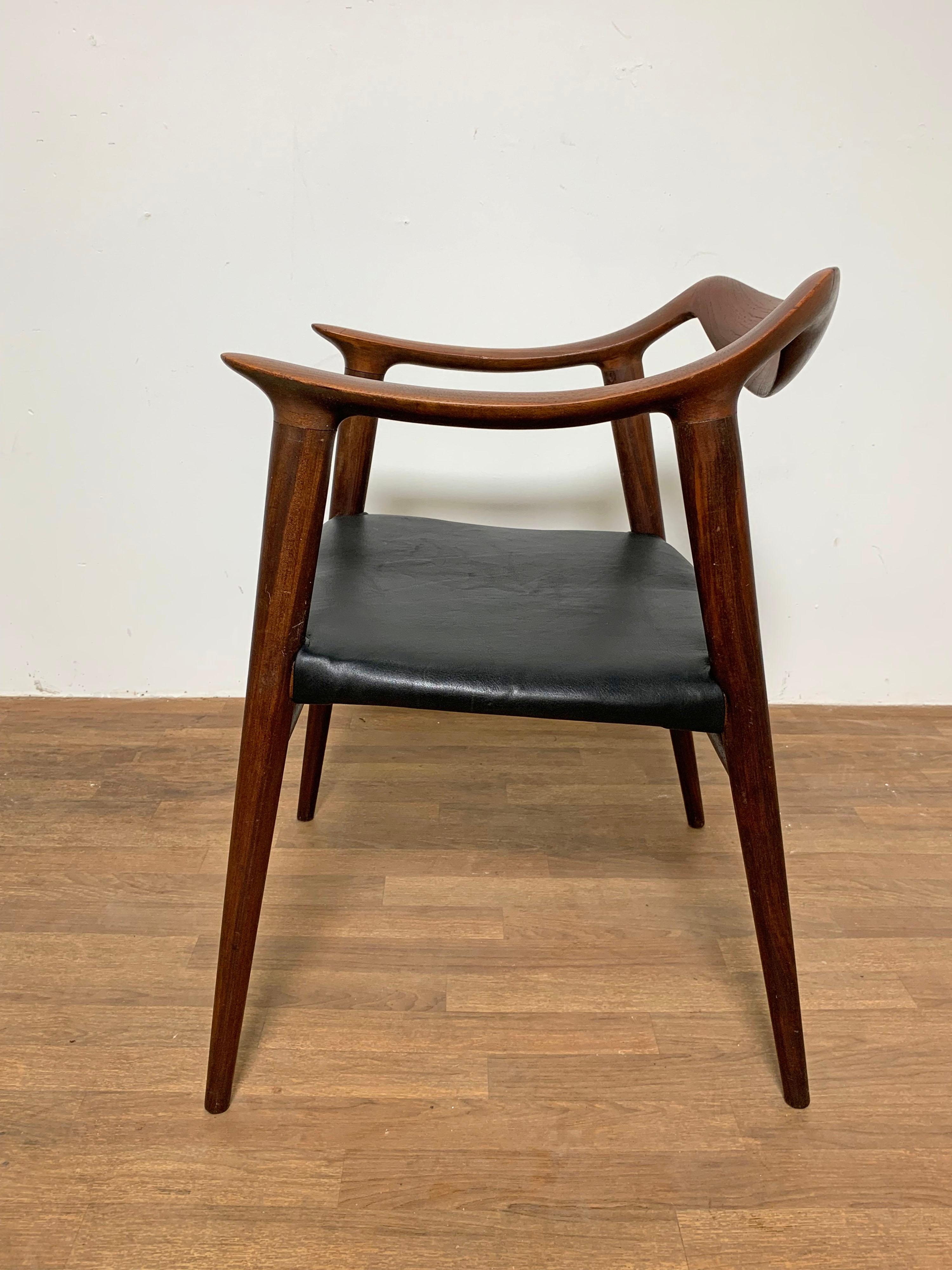 A 1950s teak armchair by the Norwegian designers Rolf Rastad and Adolf Relling upholstered in leather.