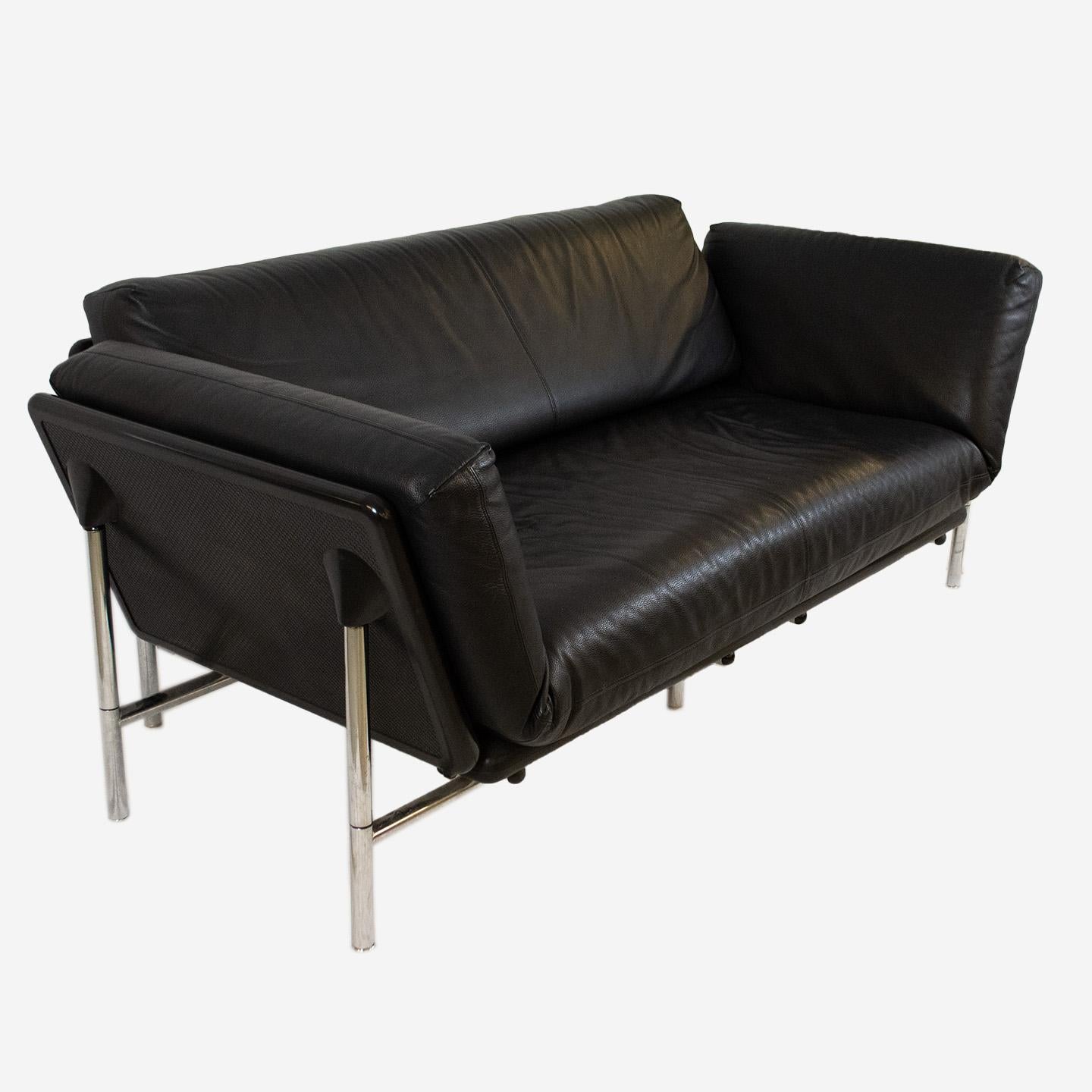 Rataplan Sofa by Dema, by Italian designer Roberto Tapinassi, is a perfect example of furniture design which marries functionality and modern design. The cushions are upholstered in black leather and are completely removable. The two armrests can be
