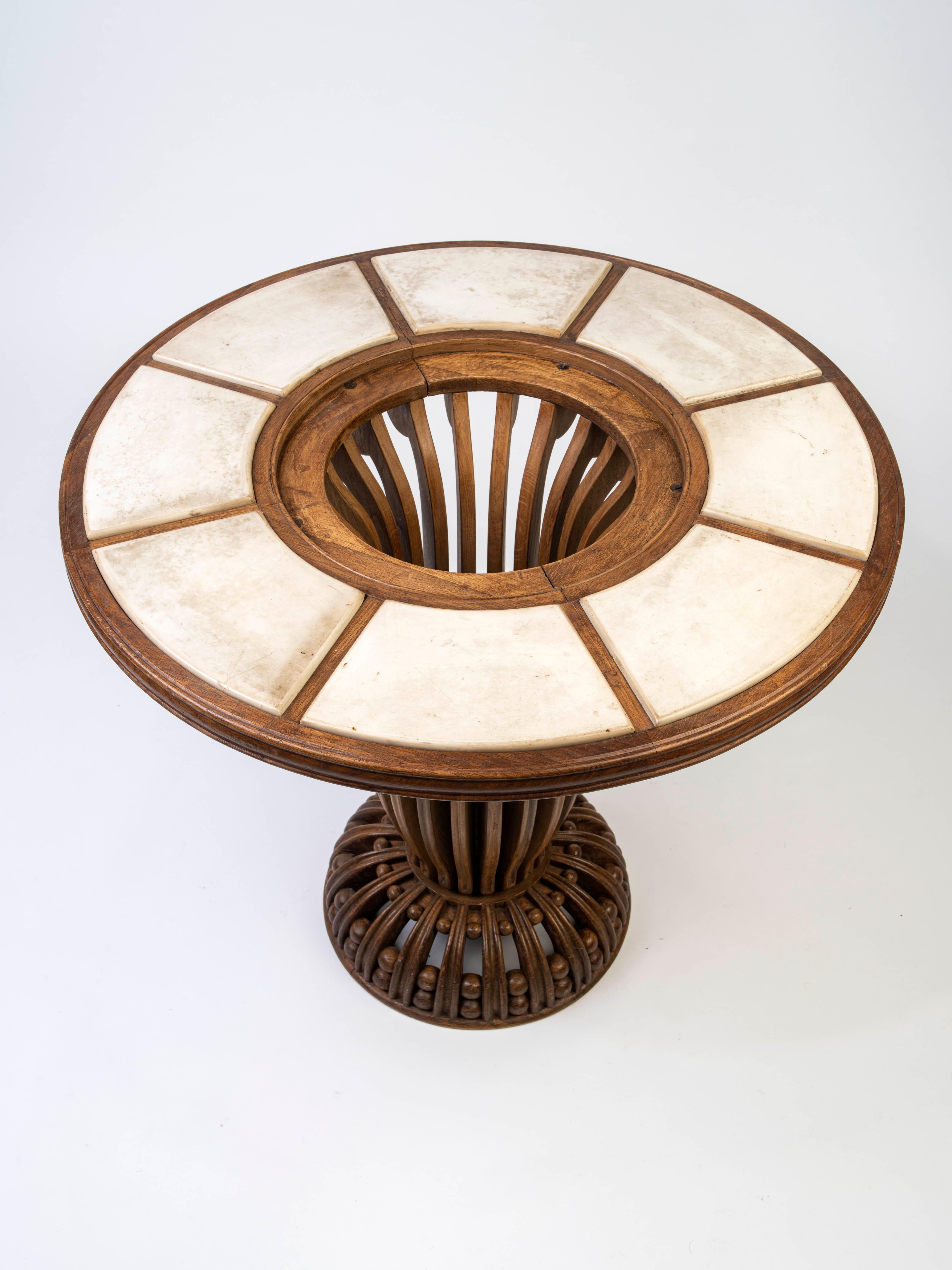A pedestal table from carved oak with a circular top, embedded with white marble plates which center around a central carved motif with floral decoration. 
Provenance :  Collection of Ms Sierra, Paris; Private collection, Paris.

Armand-Albert
