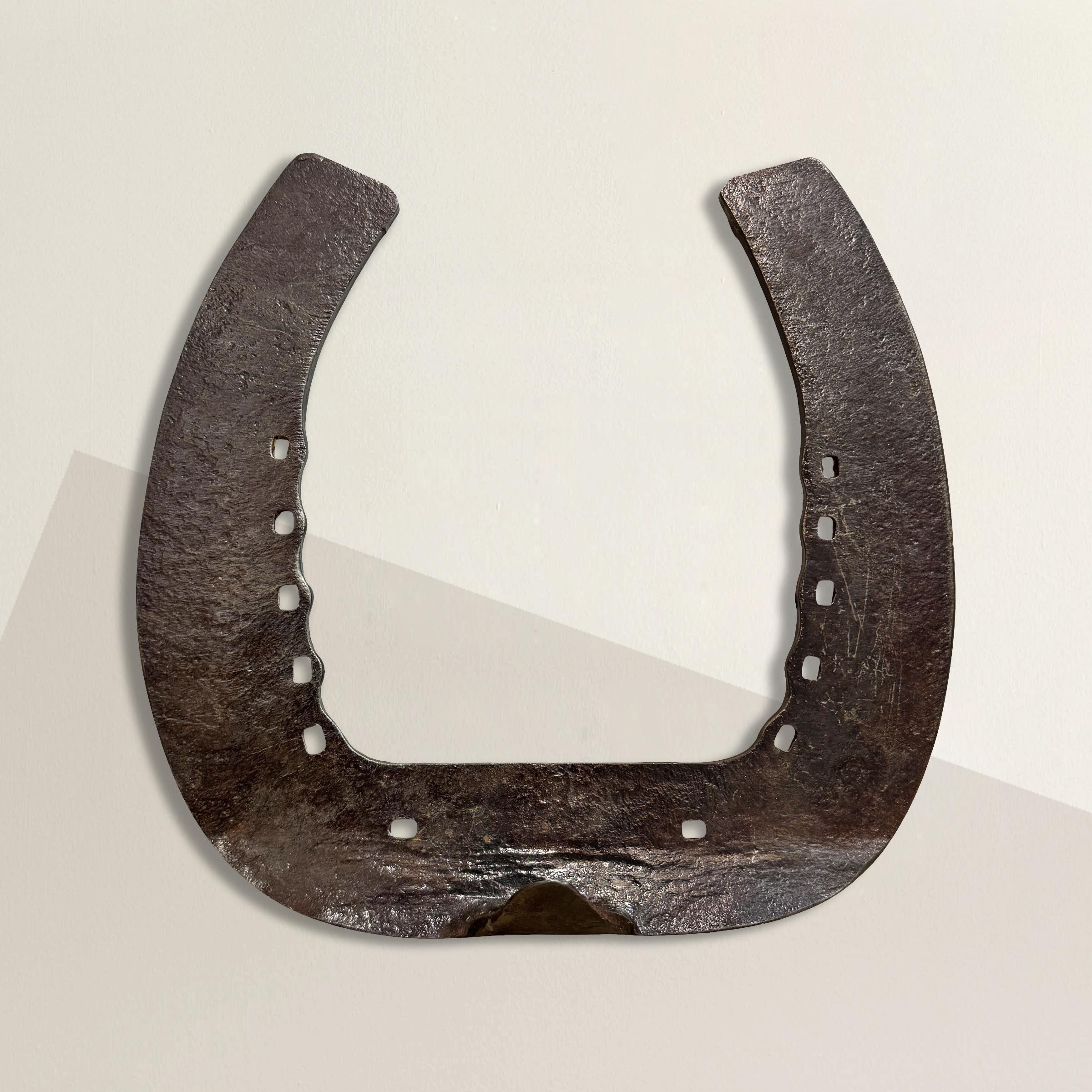 This rather large wrought iron Shire horseshoe, originally forged to shoe a mighty Shire horse, carries a piece of equestrian history. Known as gentle giants, Shire horses are among the largest and strongest draft breeds, revered for their ability