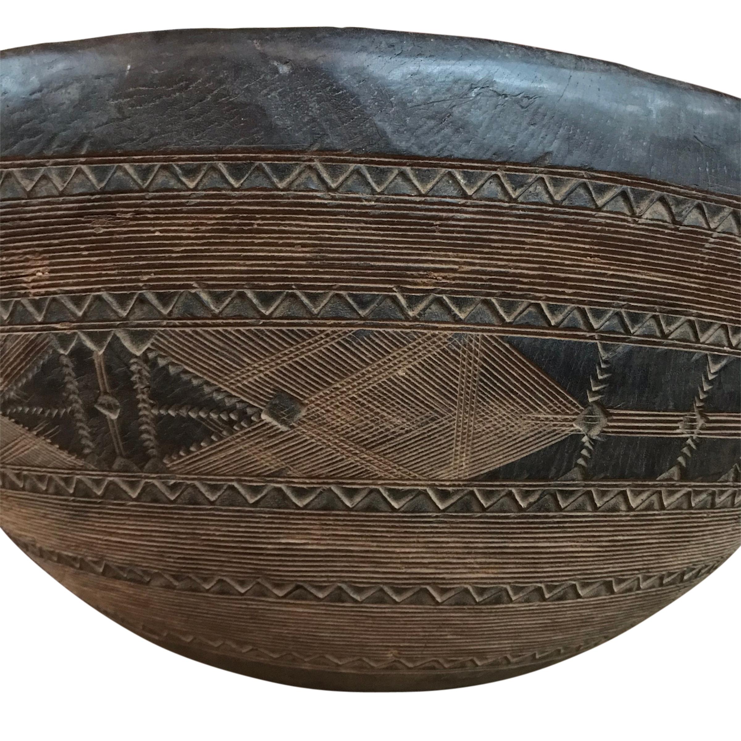 A rather large early 20th century Tuareg bowl carved of a single piece of wood with incised geometric patterns around the exterior. The Touareg are nomadic pastoralists who inhabit the Saharan region of Northern Africa. Because so many of their