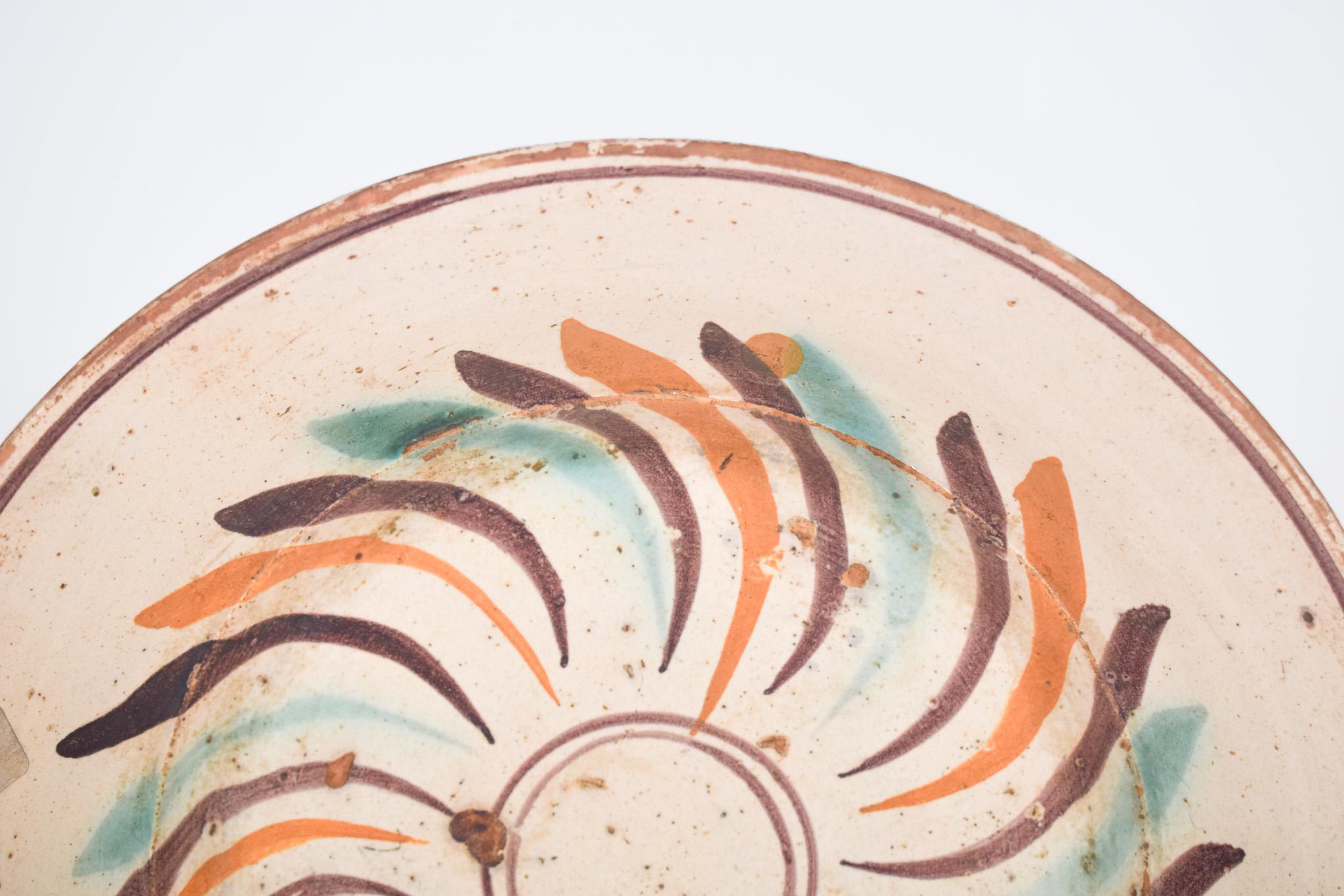 “Ratinho” bowl, in Portuguese earthenware from Coimbra.
This bowl stands out for its traditional and rustic decoration, typical of Portuguese ceramics. The piece features a vibrant color palette, with a predominance of earthy tones, orange, aqua