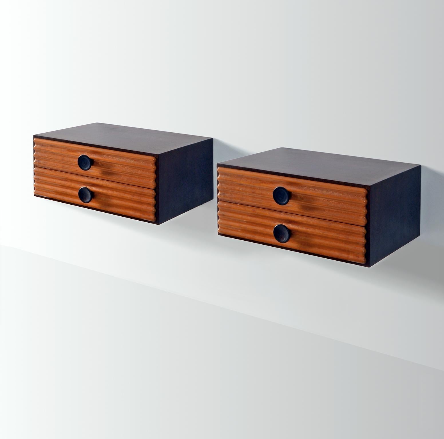 Rationalist wall-mounted bedside cabinets, Italy ca. 1930. Each cabinet has two drawers in molded wood with round blackened handles. The top and sides are stained.