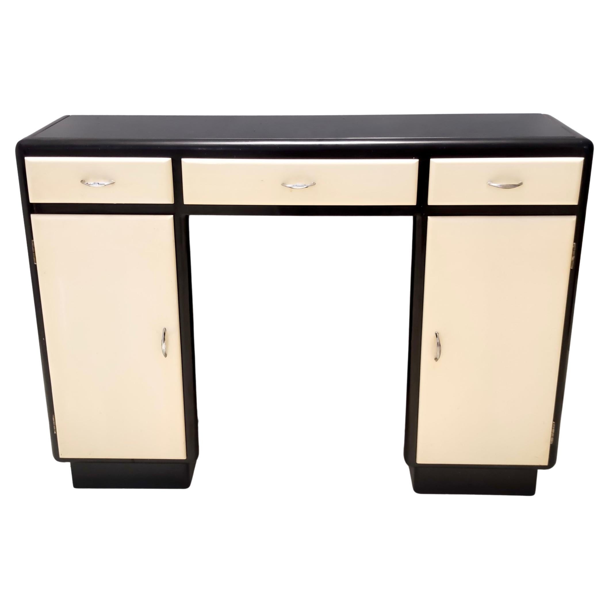 Made in Italy, 1940s.
This entryway console table / cabinet is made in lacquered beech, with a black opaline glass top and features nickel-plated brass handles . 
This is a vintage piece, therefore it might show slight traces of use such as its