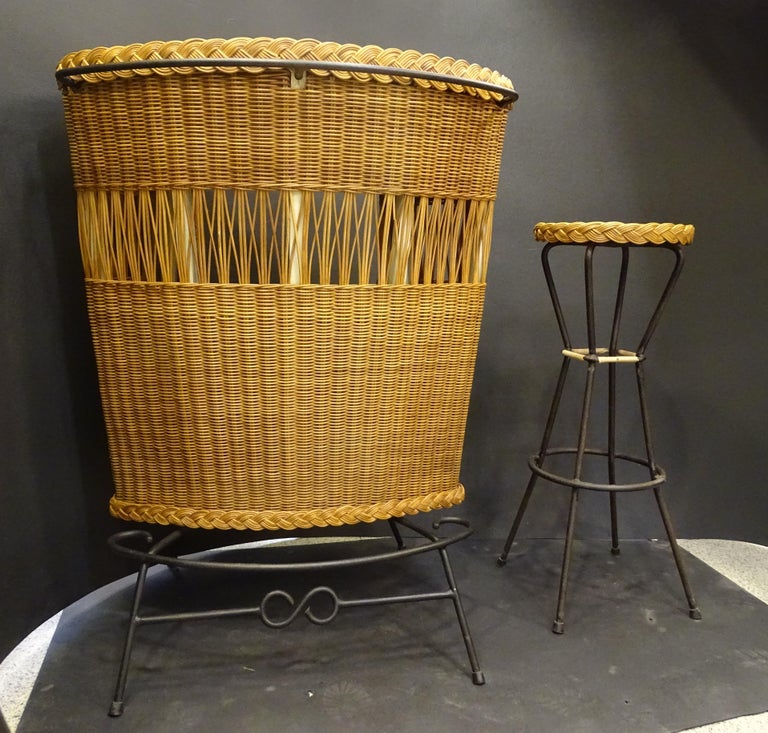 Gorgeous Italian corner bar cabinet made of wicker and wrought iron, with a curved profile that tends to be corner. Inside, the space is divided into two wooden shelves, perfect for placing bottles or glasses. The envelope is lined with imitation