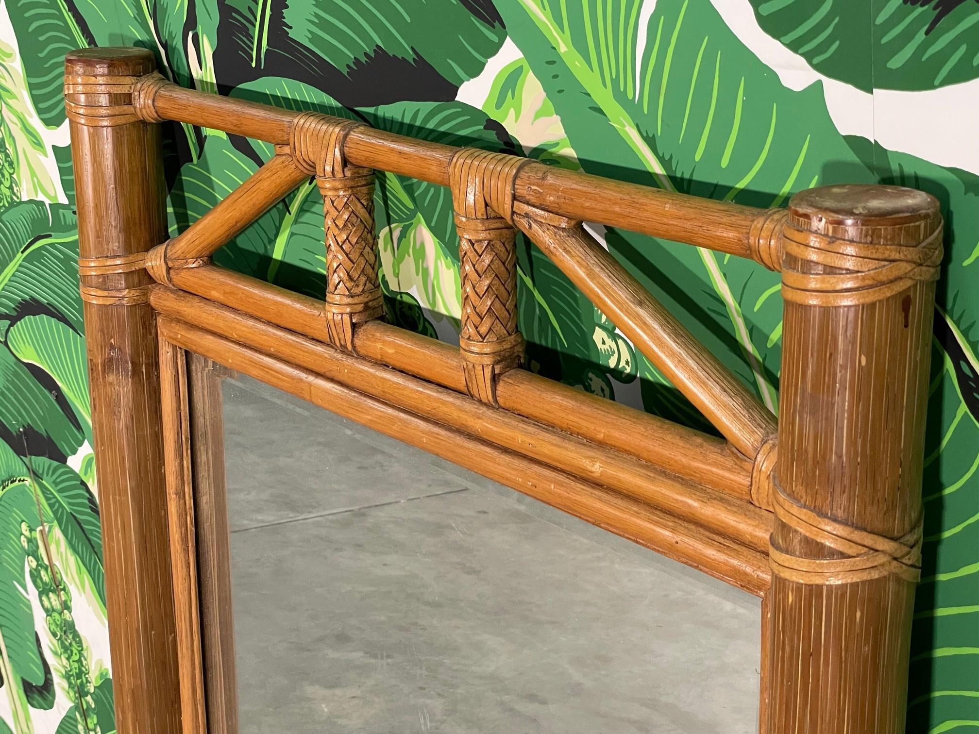 Tropical style wall mirror features bamboo and rattan frame with leather wrapped bindings. Good condition with imperfections consistent with age. May exhibit scuffs, marks, or wear, see photos for details.

 