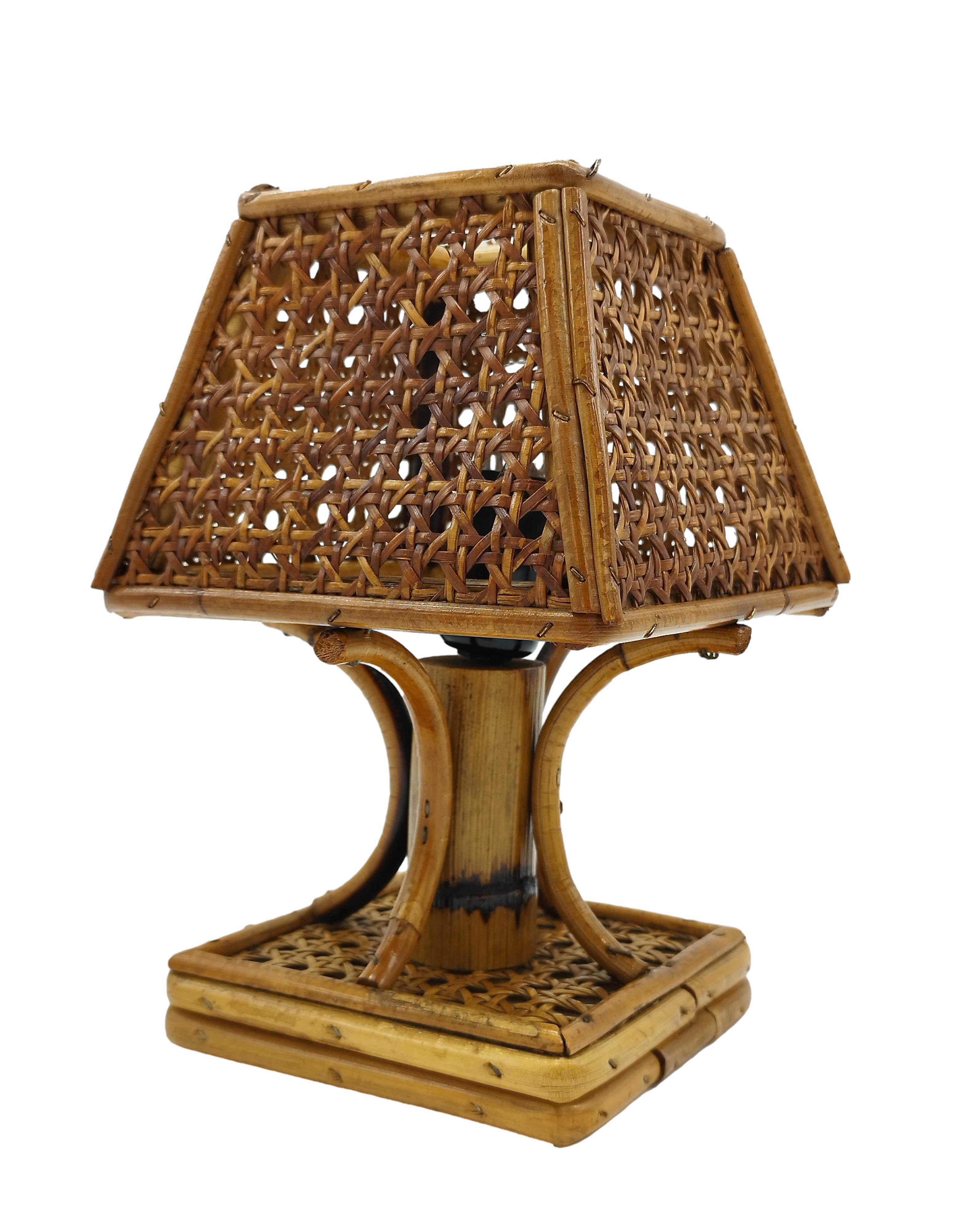 A bedside lamp handmade in Italy between the 1950s and 1960s.
The structure of the lamp was made of curved rattan canes and the lampshade, made of wicker cane webbing, is in the shape of a pagoda reminiscent of the Chinese Chippendale style.
This