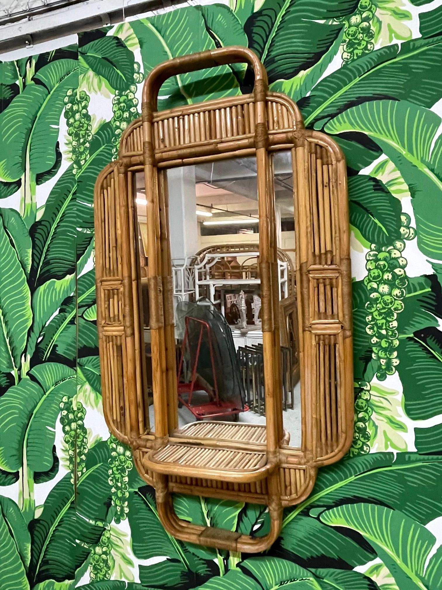 Rattan wall mirror features small shelf and reed detailing. Very good condition with minor imperfections consistent with age.