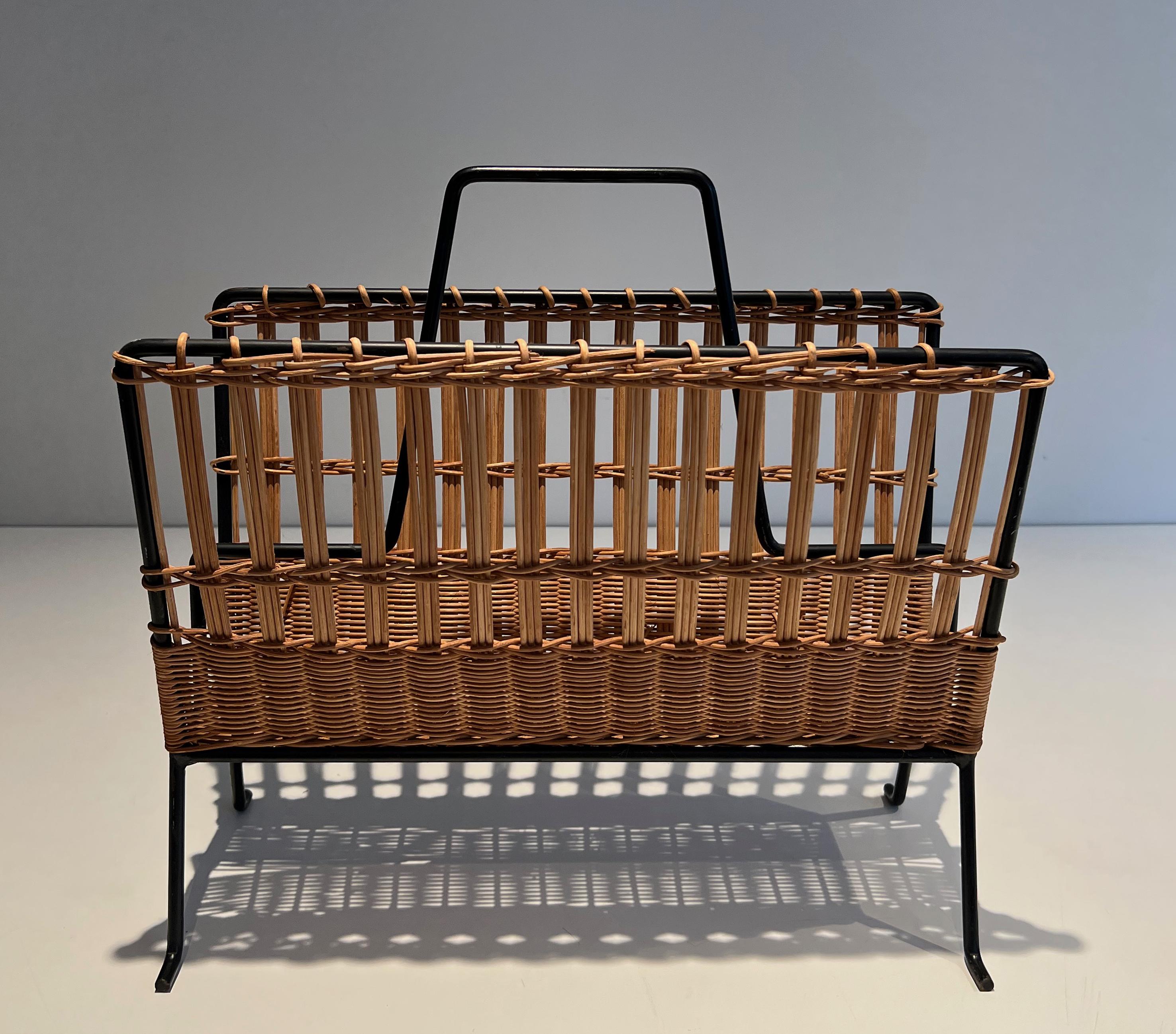 Questo simpatico portariviste è realizzato in rattan e metallo laccato nero. Si tratta di un'opera francese. Circa 1950