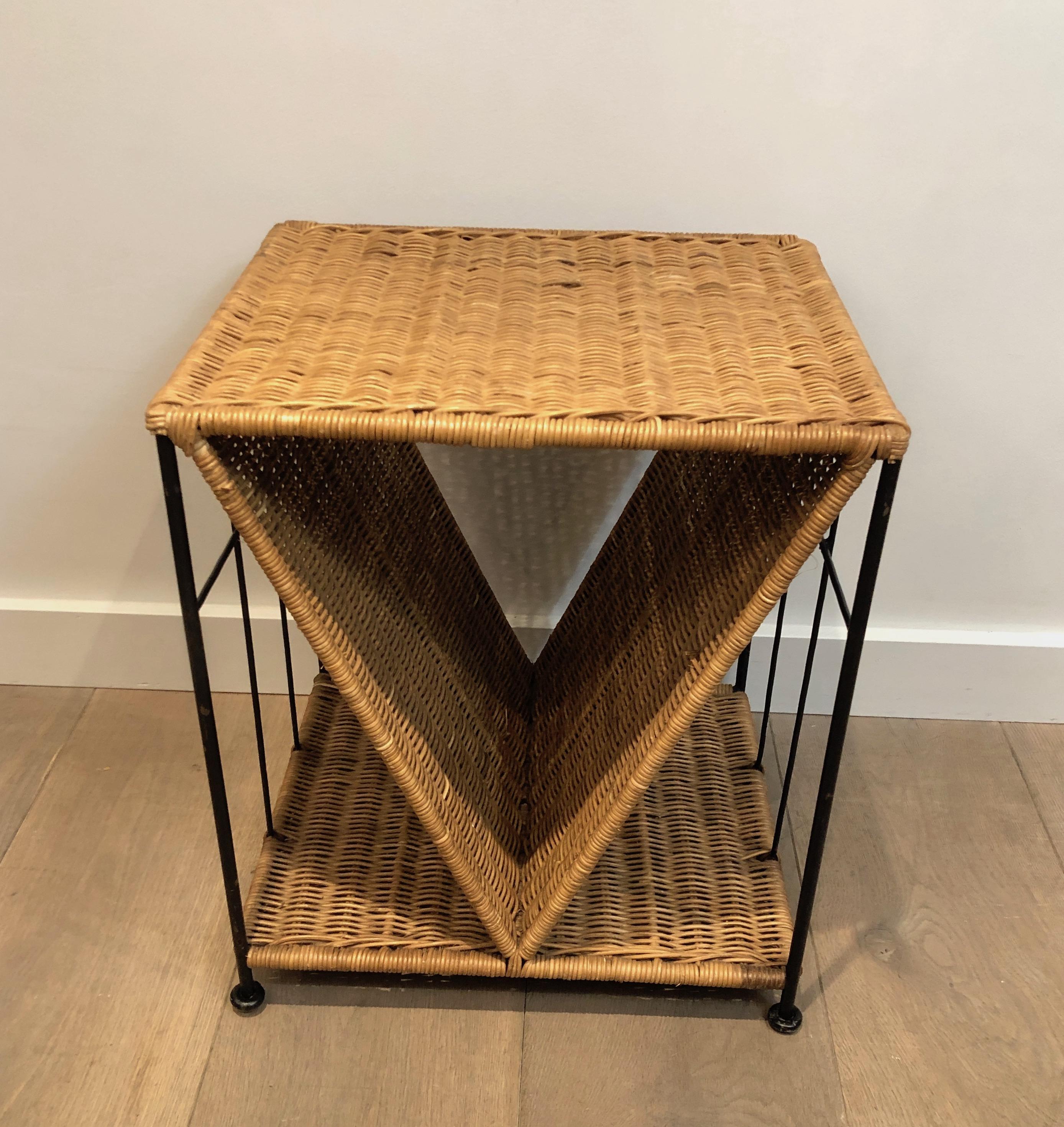 This design side table is made of rattan and black lacquered metal. This is a French work, circa 1970.