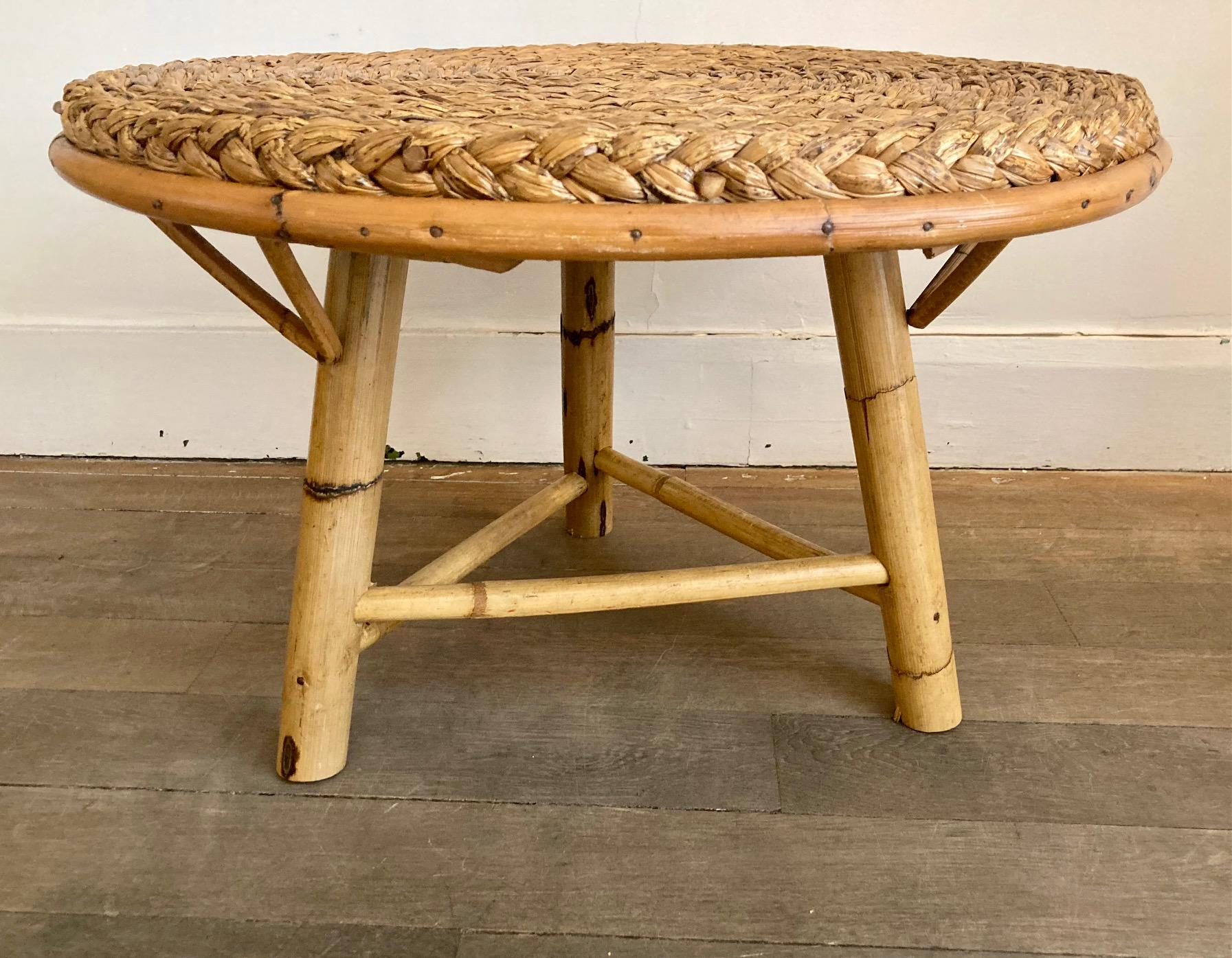 Round coffee table with a braided rush top. 
Placed on a rattan tripod base.
In the taste of Audoux Minet 

Adrien Audoux et Frida Minet created rattan, bamboo and rope furniture for their shop established in Golfe Juan in 1942

Dimension