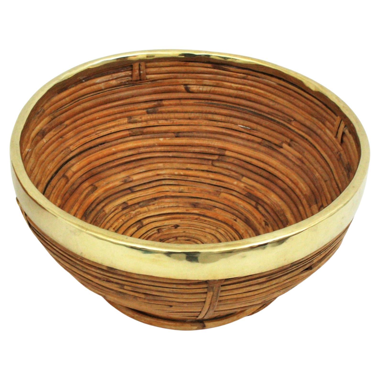Mid-Century Modern brass and bamboo / rattan large bowl, centerpiece or basket.
It has a brass trim covering the top.
Handcrafted in Italy, 1970s. 
This piece has a design inspired in Gabriella Crespi designs.
Use it as fruit bowl or centerpiece