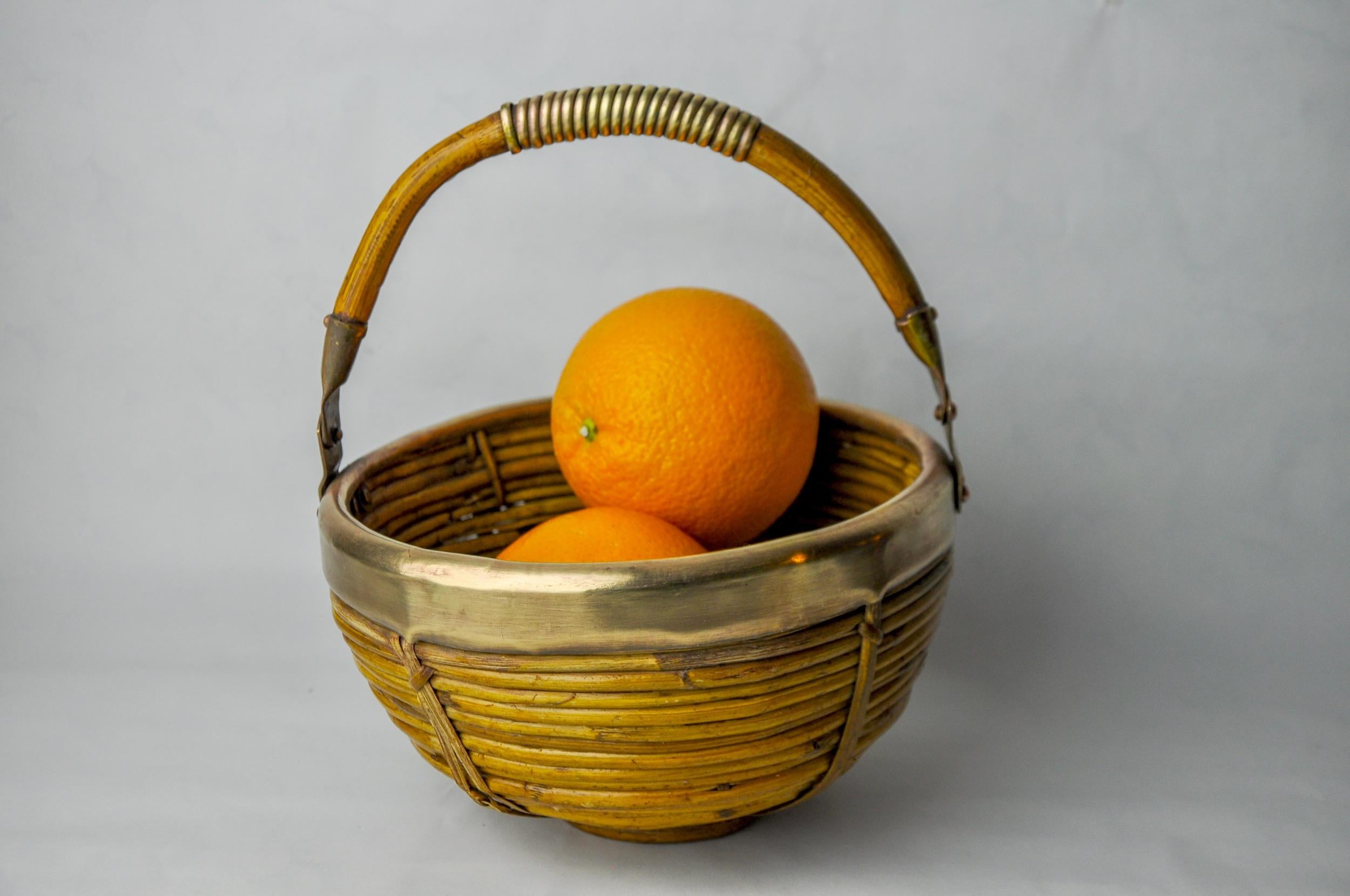 Very nice basket with rattan handle and brass made in italy in the 1970s. Round shape, mid-century modern style. It is inspired by the drawings of gabriella crespi. Beautiful decorative object that will bring a real design touch to your interior.