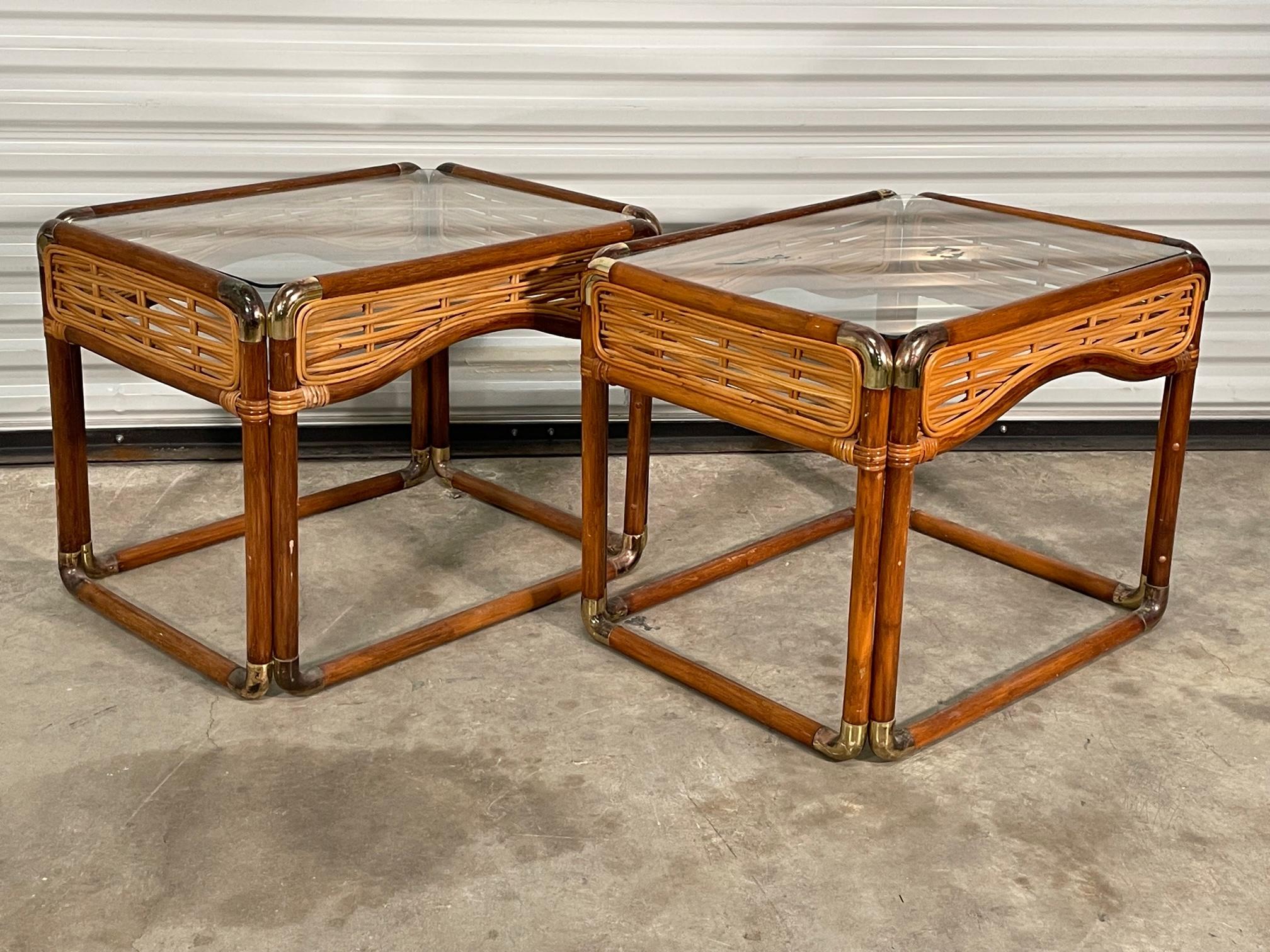 Pair of rattan side tables feature brass joints and woven pencil reed skirts. Good condition with imperfections consistent with age, see photos for condition details.

