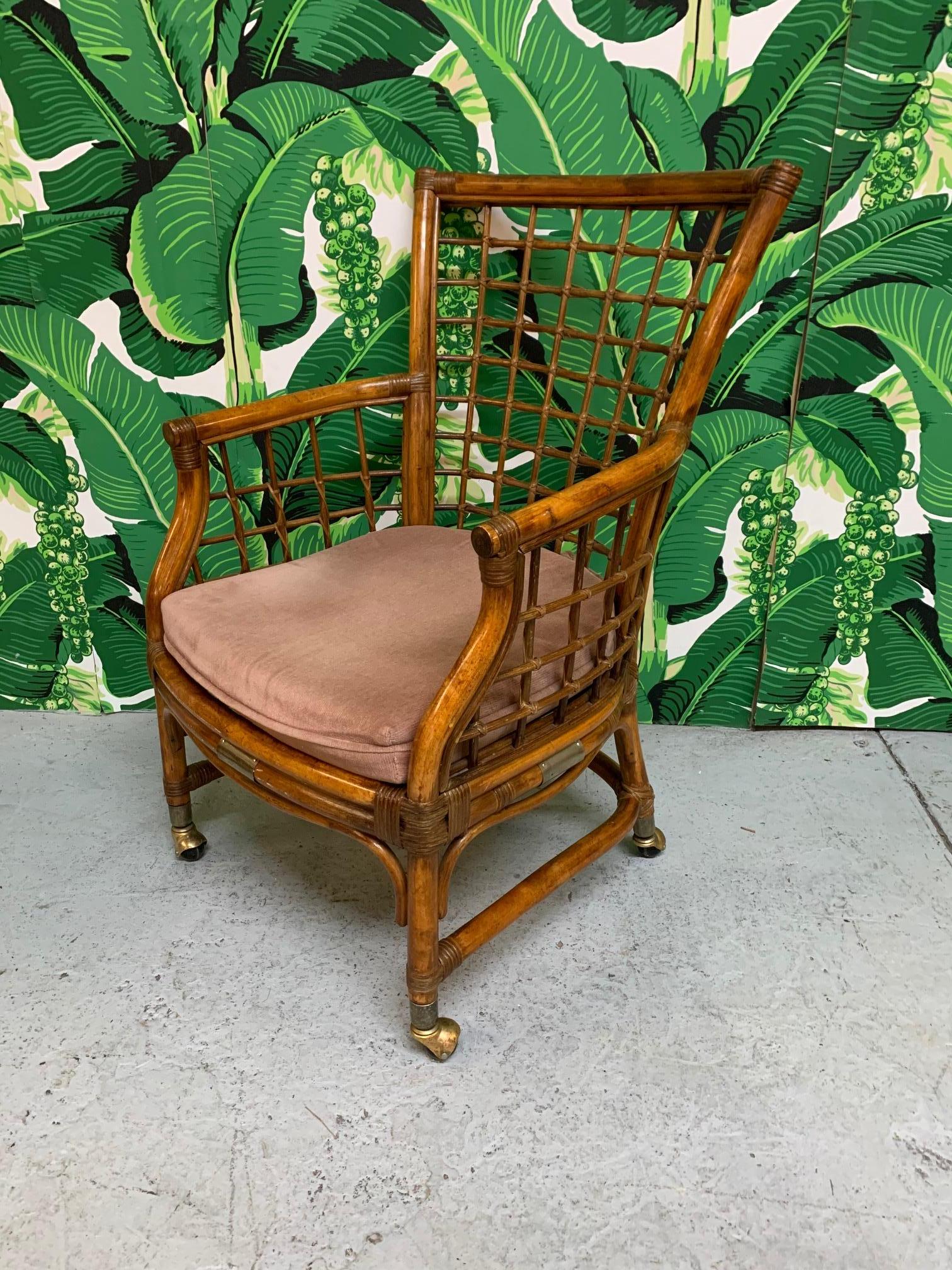 Set of four midcentury rattan dining chairs feature a rich, deep brown finish and brass accents. Chairs roll on original brass casters (can be removed). Very good vintage condition with minor imperfections consistent with age.
   