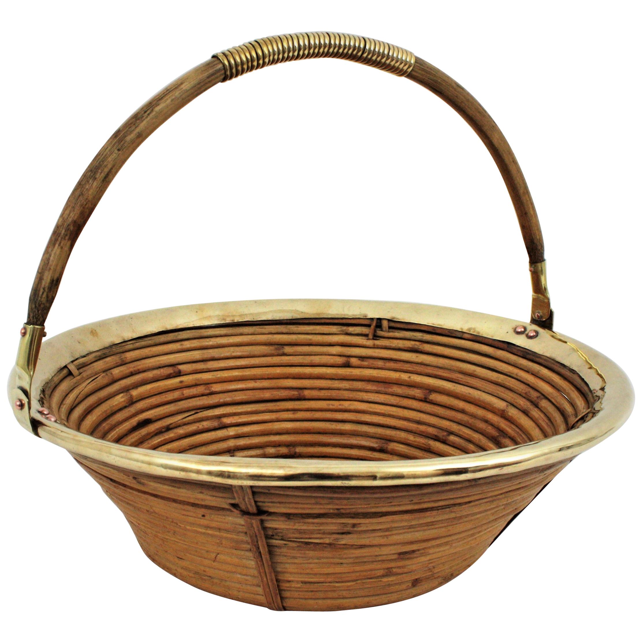 Mid-Century Modern brass and bamboo / rattan large conical basket bowl with a single handle. Handcrafted in Italy, 1970s. 
It has a brass trim covering the top and brass detailings at the handle. Inspired on Gabriella Crespi designs.
Use it as
