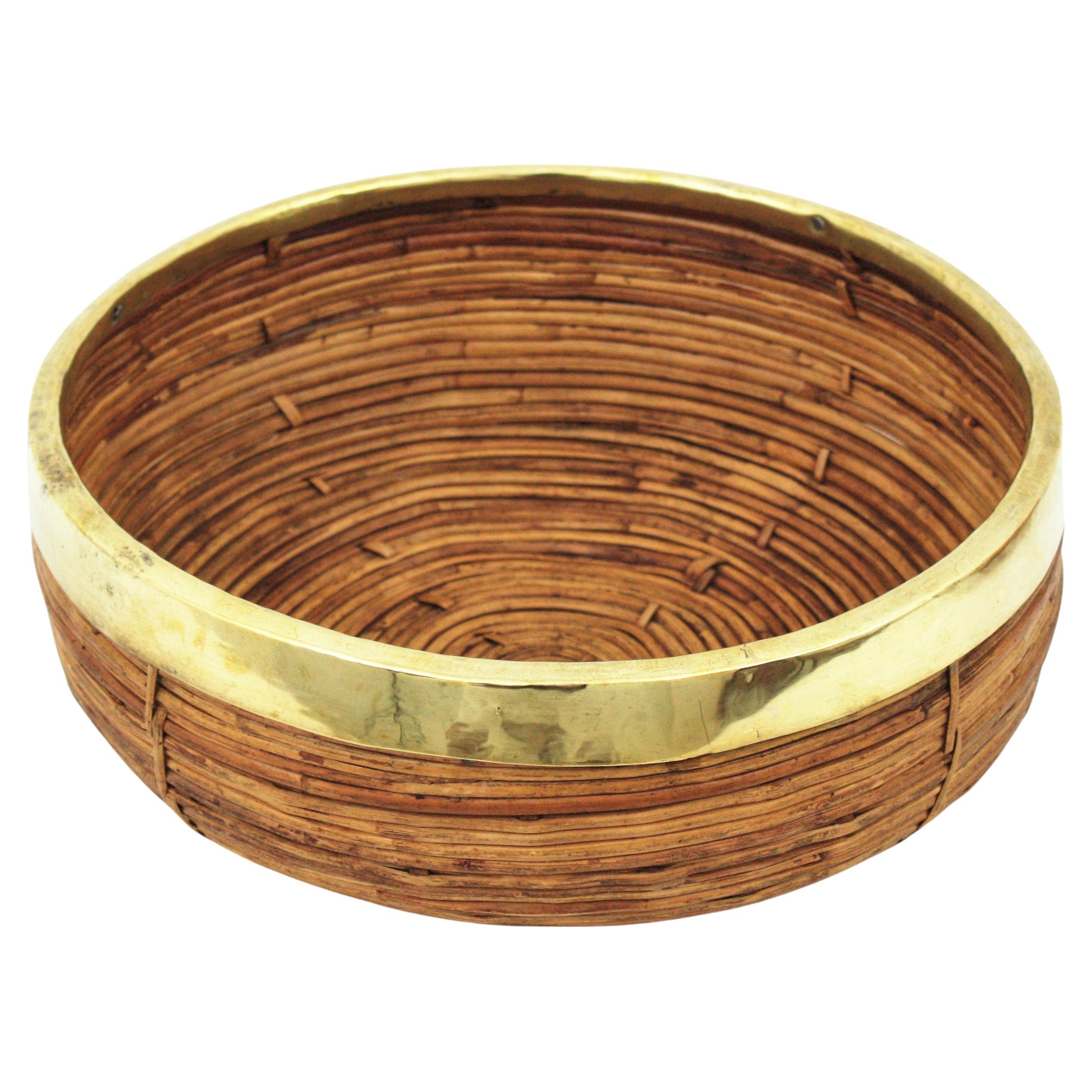 Mid-Century Modern brass and bamboo / rattan large round bowl, centerpiece or basket.
It has a brass trim covering the top.
Handcrafted in Italy, 1970s. 
Use it as fruit bowl or centerpiece to add a stylish Midcentury accent in a kitchen. Perfect to