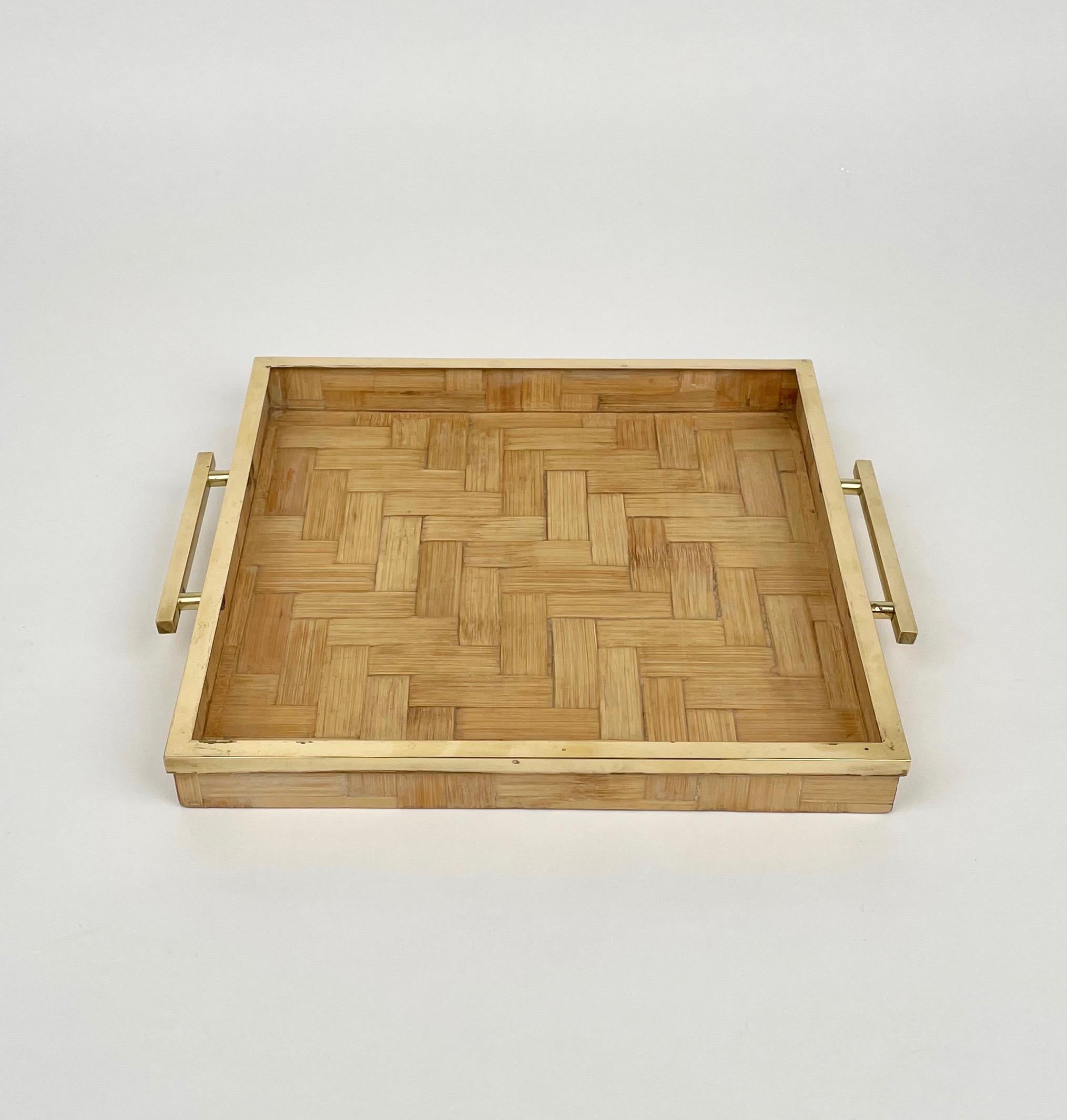 Squared serving tray in rattan featuring brass borders and handles attributed to Tommaso Barbi. 

Made in Italy in the 1970s.