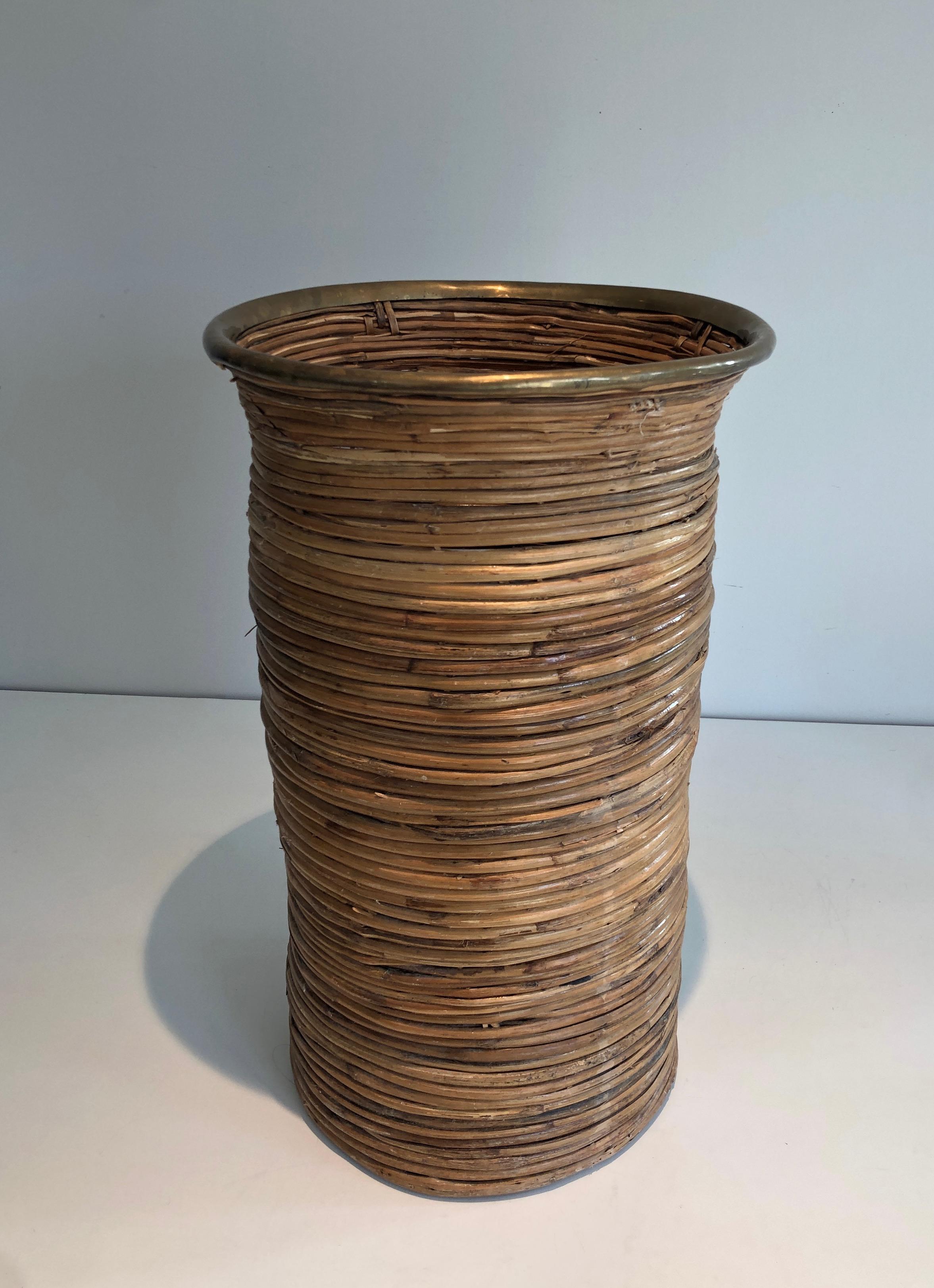 This unusual umbrella stand is made of rattan with a brass circle on top. This is a French work. Circa 1970