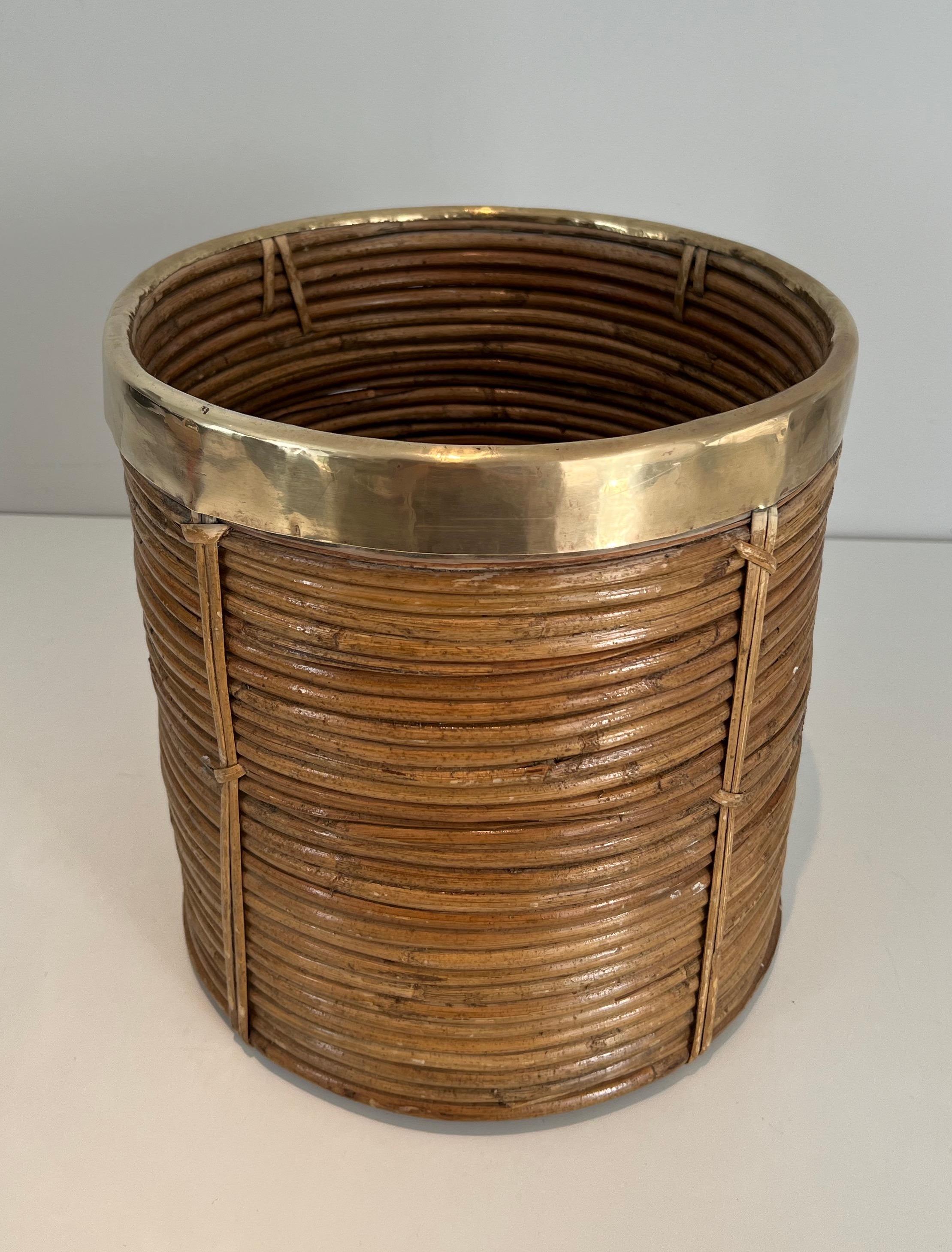 Questo simpatico cestino è realizzato in rattan e ottone. Questa è un'opera italiana. Circa 1970