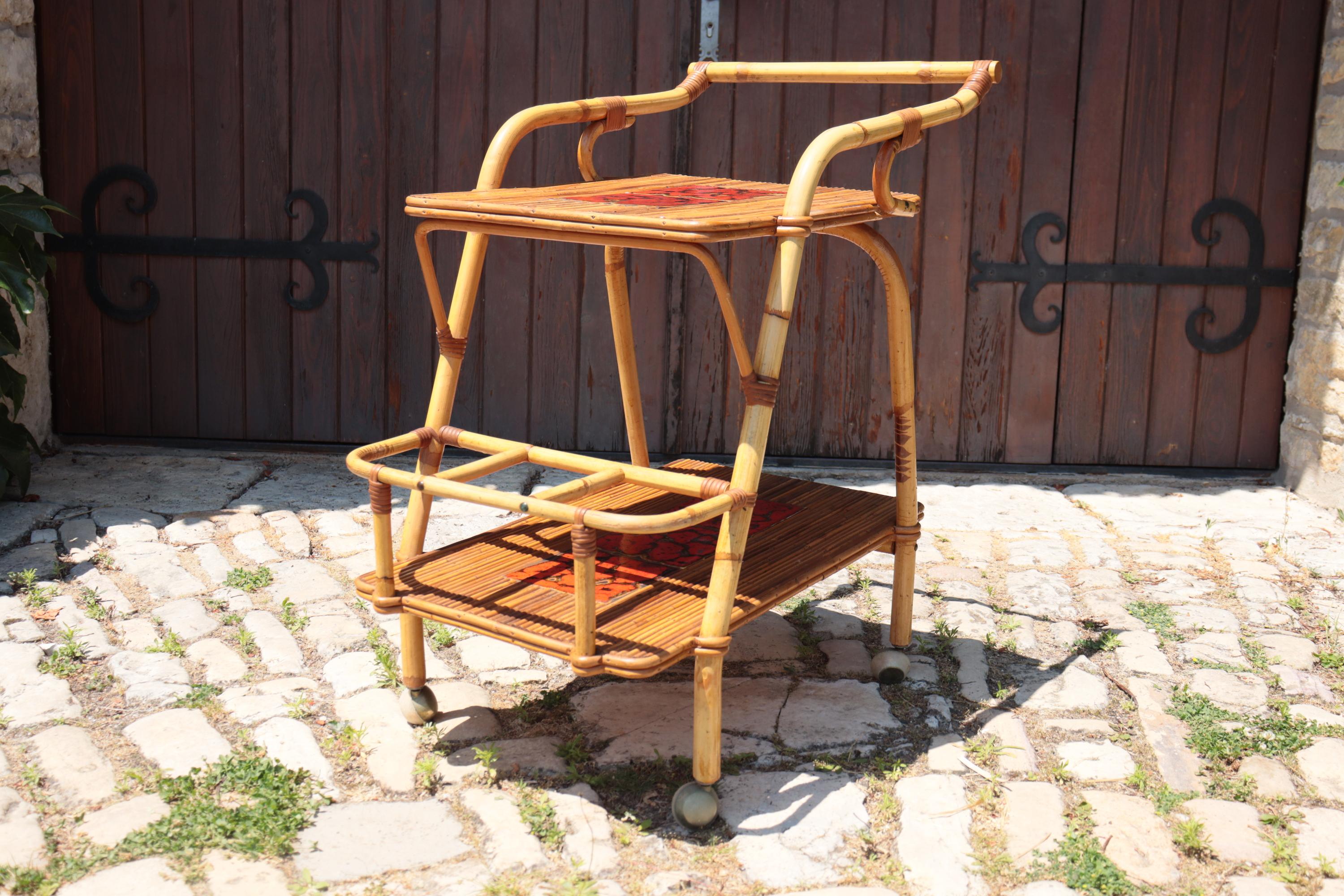 Raro tavolino a due piani in rattan naturale, attribuito al famoso duo di designer francesi Adrien Audoux e Frida Minnet, figure chiave dell'arredamento rustico moderno degli anni '40 e '50. Struttura in rattan curvo con decorazione a legature,