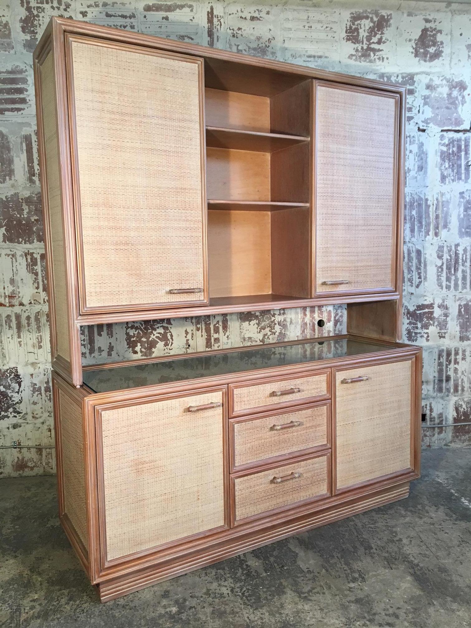 Vintage buffet with hutch features rattan door and drawer fronts and faux bamboo pulls. Credenza has glass top. Three drawers and ample storage behind four doors. Top hutch can be removed, and lower piece can be used as a server. Very good vintage