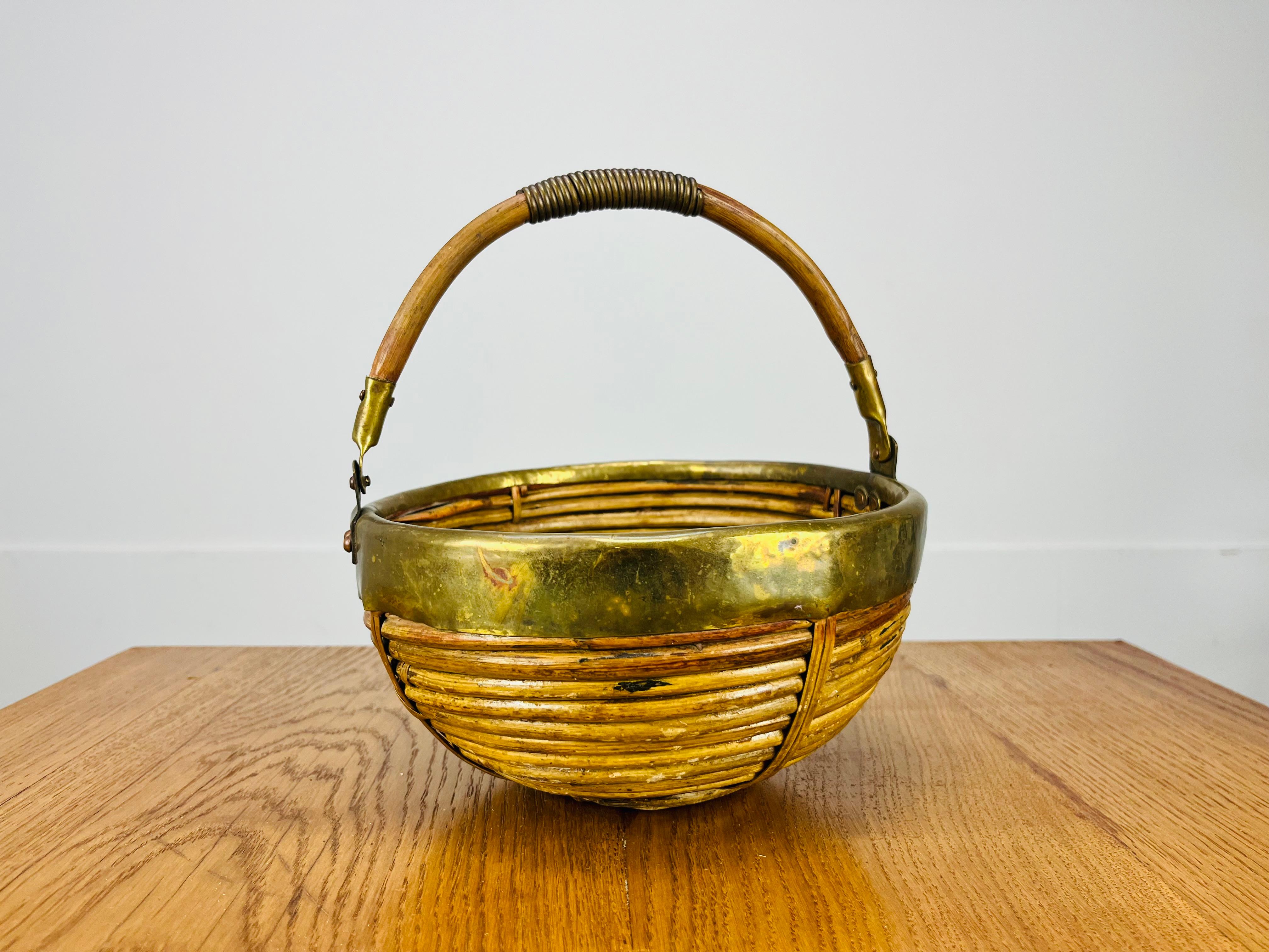 Beautiful Italian rattan and golden brass basket in the style of Gabriella Crespi, around 1960's. Good condition, a very nice piece of organic furniture.

Measurements : total height with handle up 23,5 cm, height of the basket 13 cm, width 22 cm,
