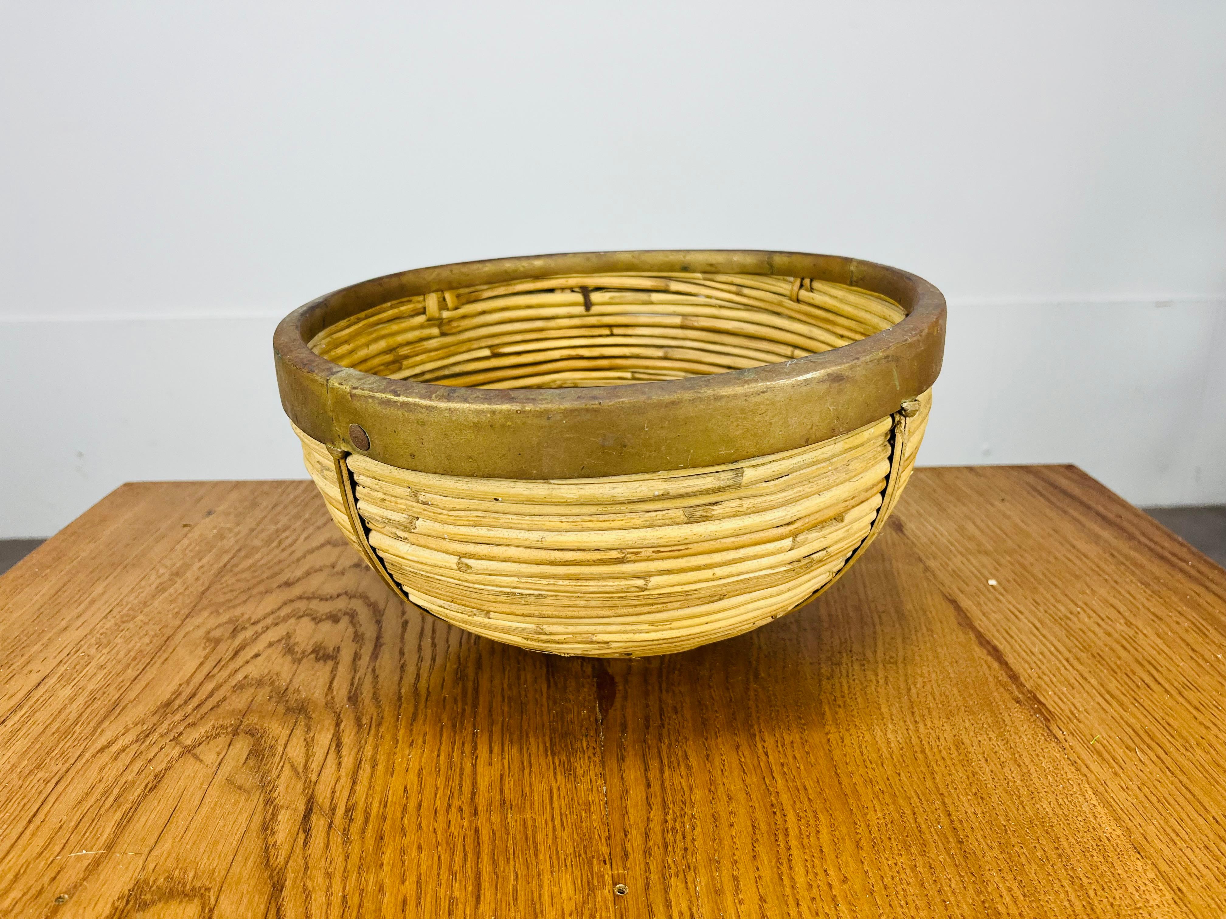 Beautiful Italian rattan and golden brass basket in the style of Gabriella Crespi, around 1960's. Good condition, a very nice piece of organic furniture.

Measurements : height 15 cm, diameter 26.
