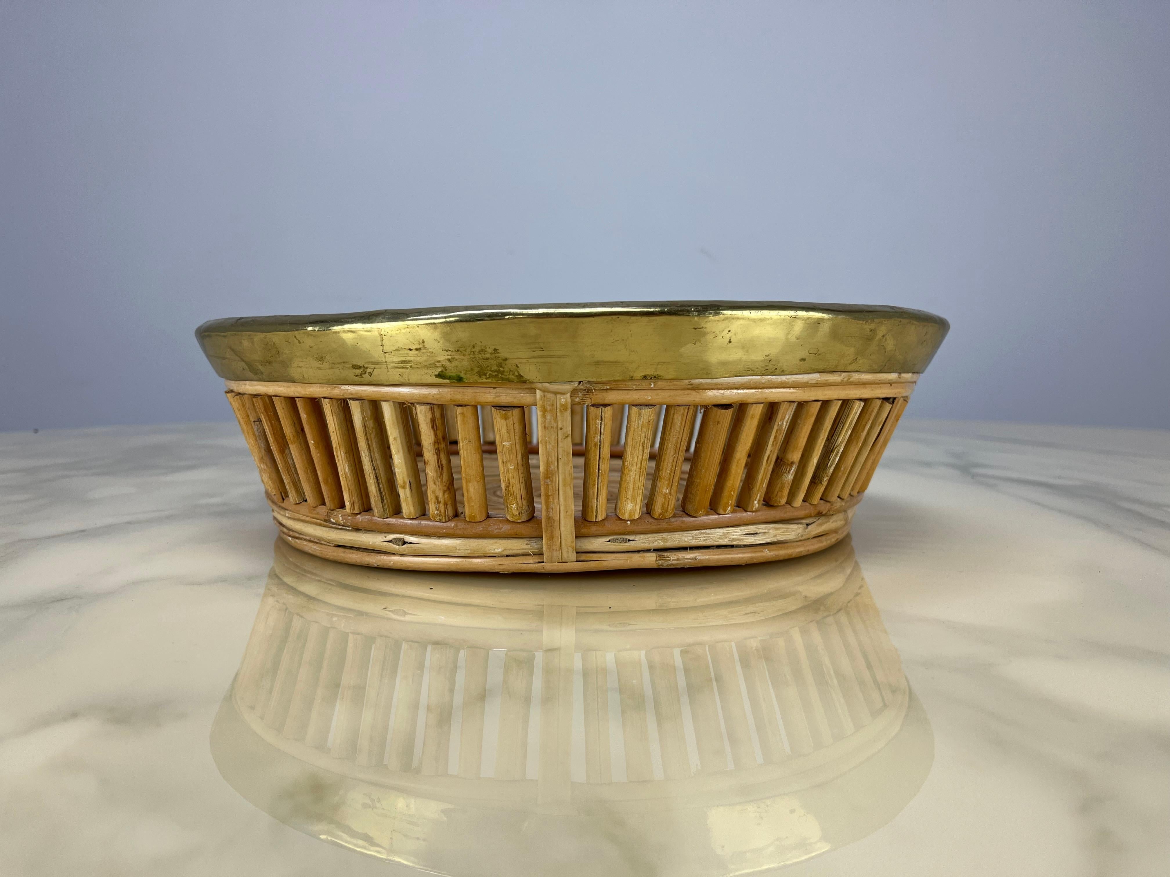 Bellissimo cesto italiano in rattan e ottone dorato nello stile di Gabriella Crespi, anni '60 circa. In buone condizioni, un pezzo di arredamento organico molto bello.

Misure: altezza 9 cm, diametro 31.
