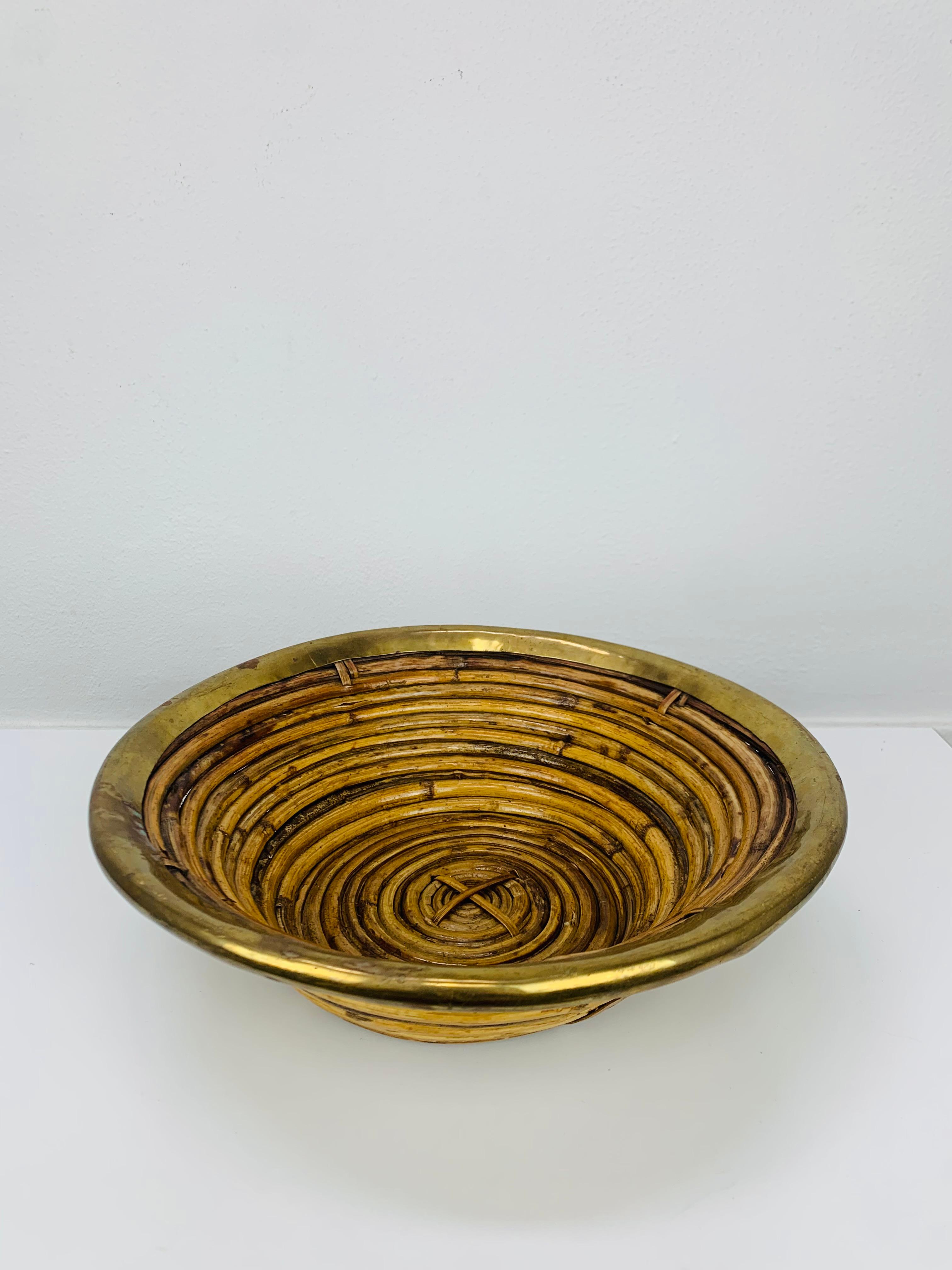 Bellissimo cesto italiano in rattan e ottone dorato nello stile di Gabriella Crespi, anni '60 circa. In buone condizioni, un pezzo di arredamento organico molto bello.

Misure: altezza 8,5 cm, diametro 28 cm.

