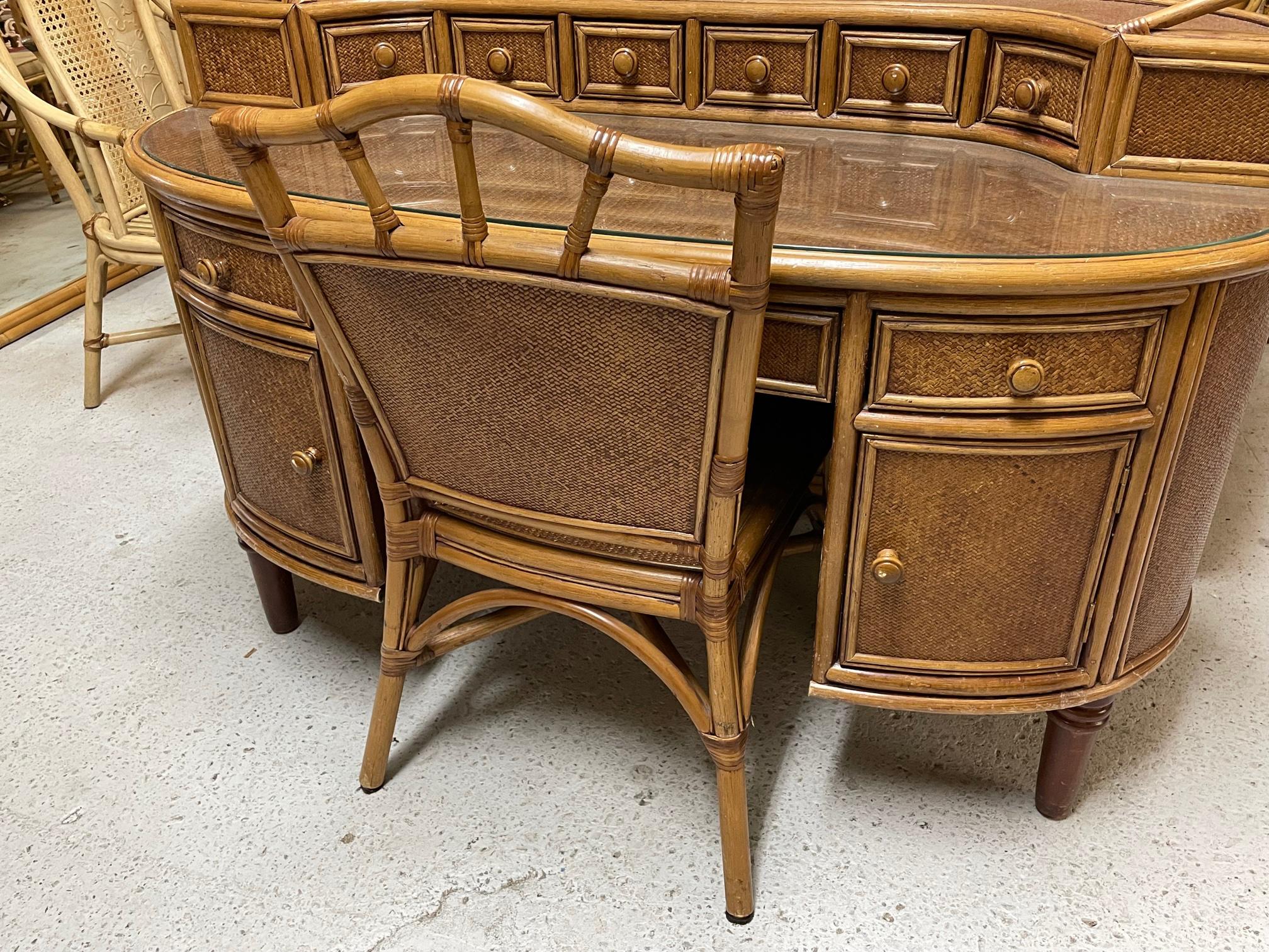 Oval secretary desk features rattan and wood construction and veneers of woven wicker in a herringbone pattern. Includes matching chair and custom cut glass top.
Measures 56