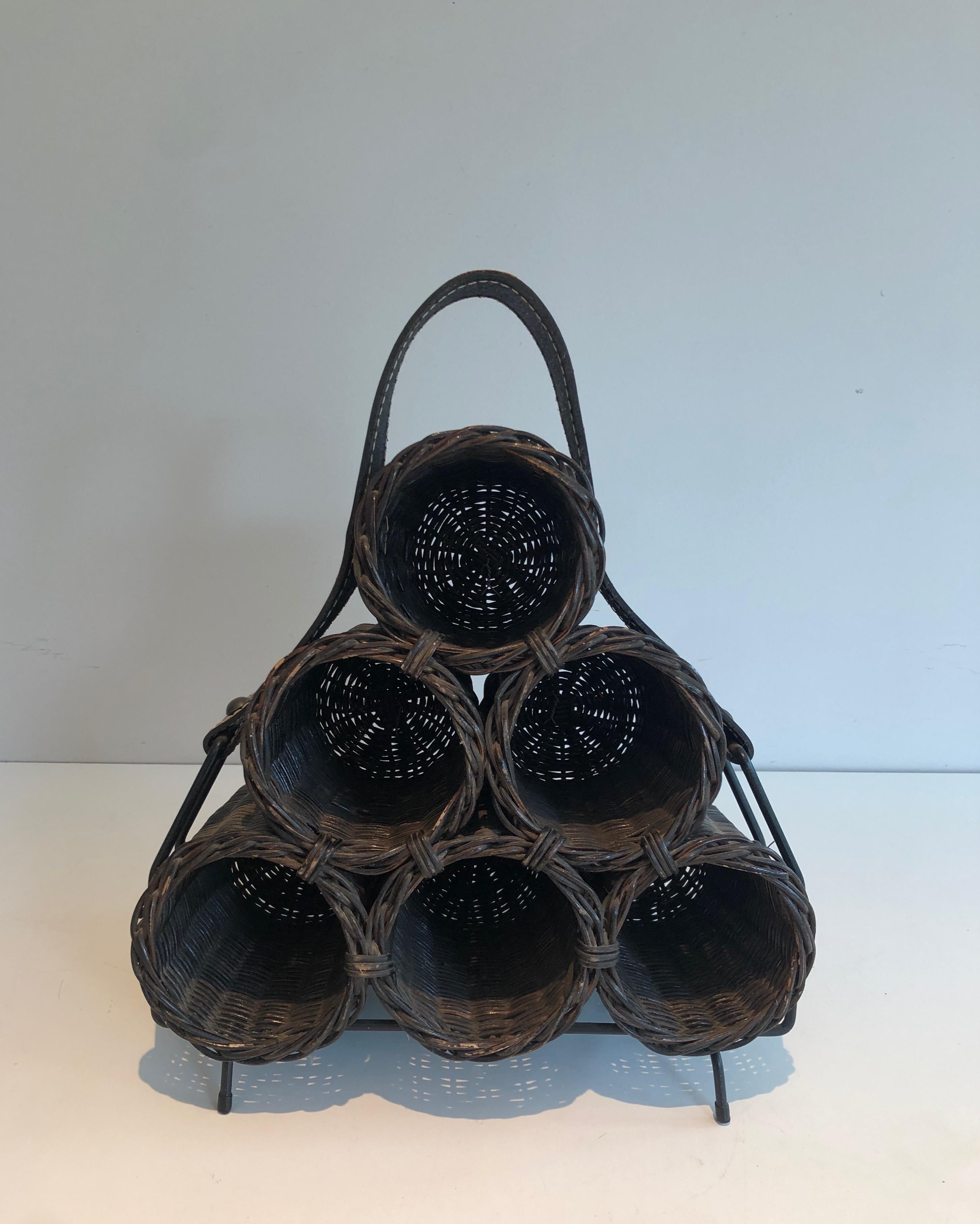 Este portabotellas está hecho de ratán y cuero. Se trata de una obra francesa. Alrededor de 1970.