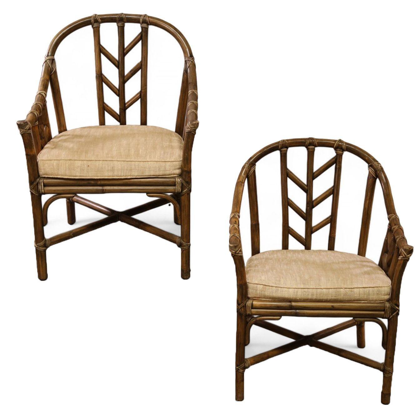 A pair of vintage McGuire rattan and leather wrapping occasional armchairs or dining chairs, featuring Craftsman details. The chairs were designed by Elinor McGuire and have a rich dark tobacco finish along with supple leather seat backs and leather