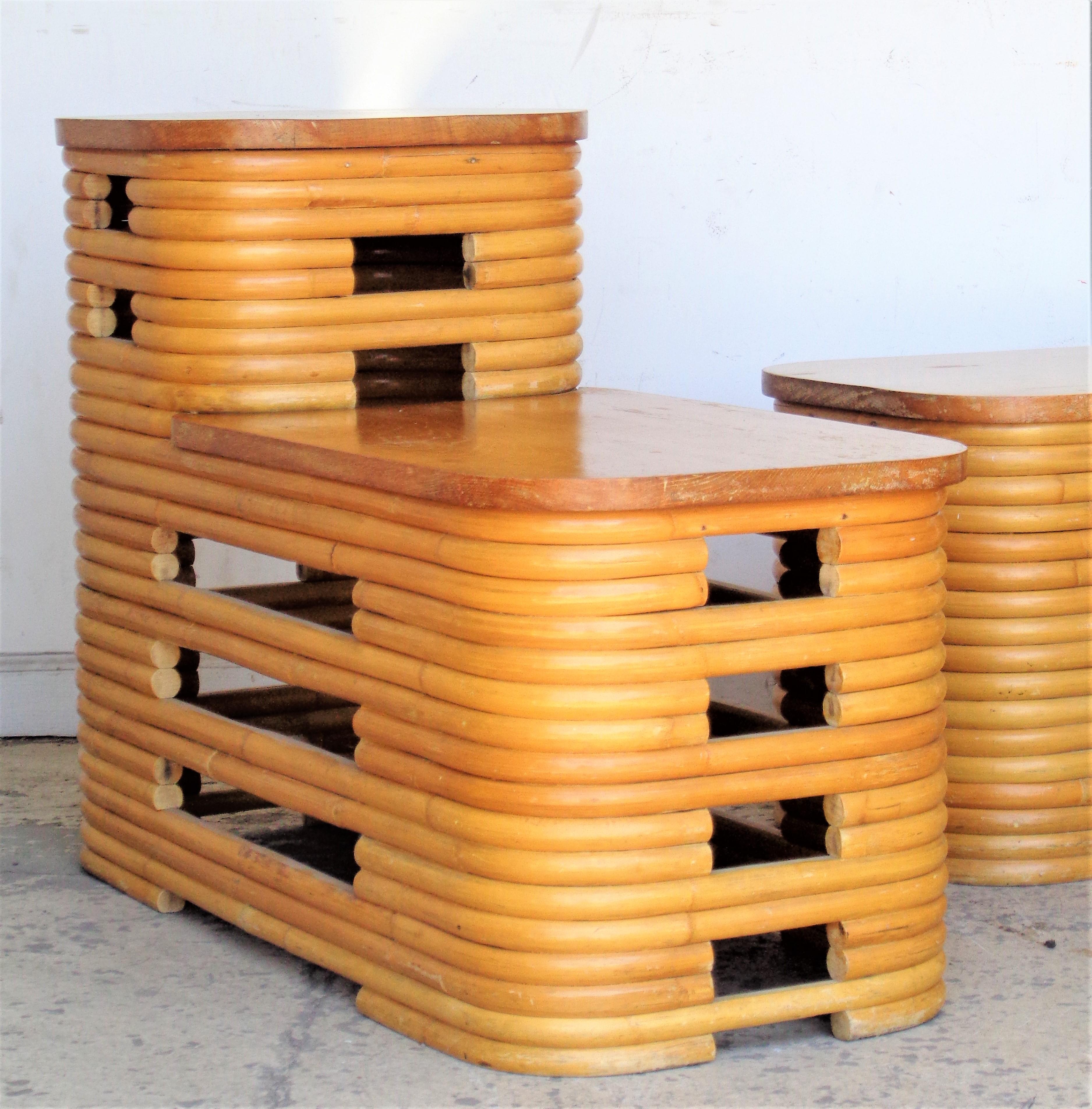 Matched pair of classic Art Deco style bent and stacked rattan two tier side / end tables with oak tops in overall great original vintage condition. Both tables with beautifully aged glowing honey colored surface. Paul Frankl design, made in Japan.