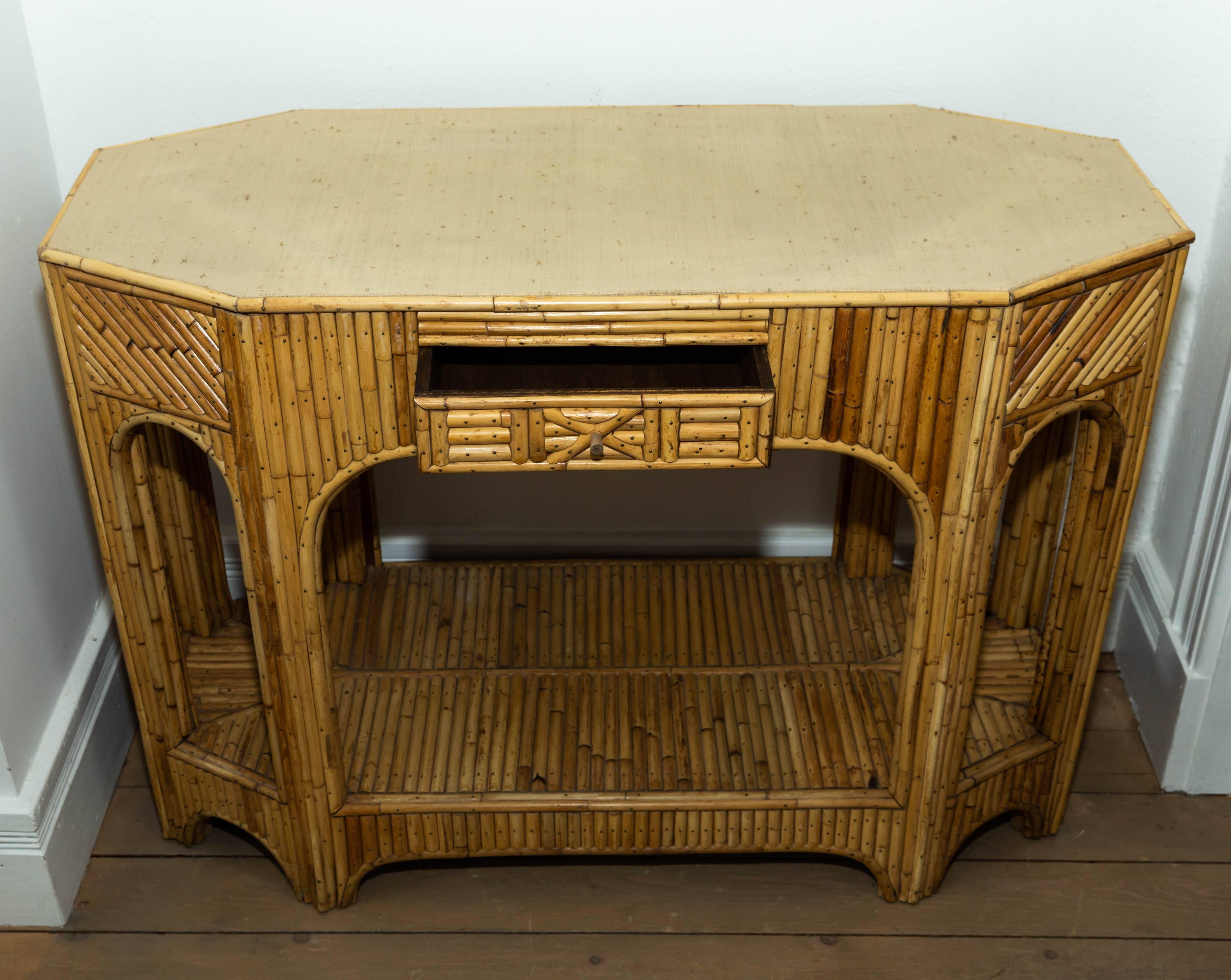 Rattan and reed console with single drawer and bottom shelf.