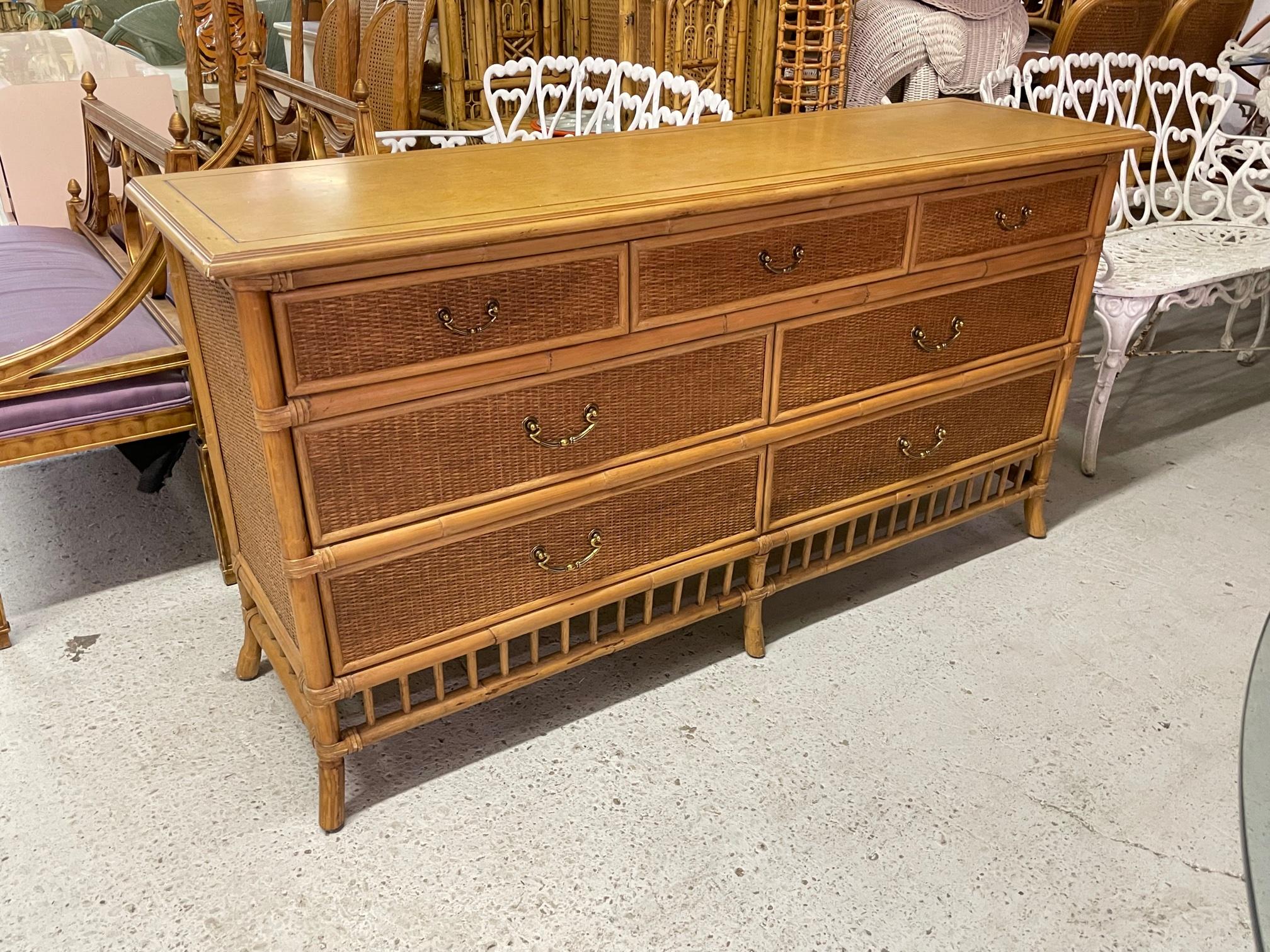 Vintage rattan dresser features wicker veneer drawer fronts and sides as well as brass hardware. Solid wood top. Very good condition with only very minor imperfections consistent with age.
