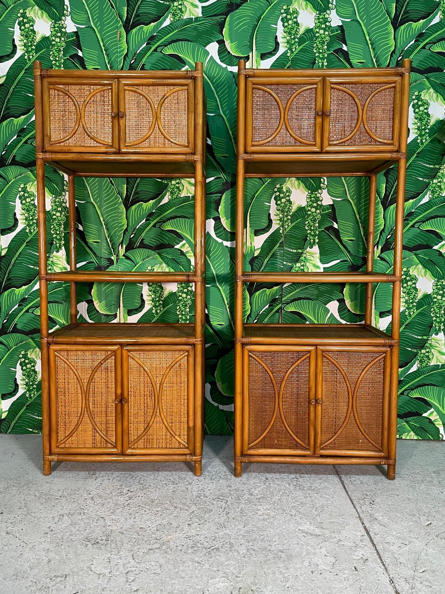 Pair of vintage rattan etageres feature woven wicker veneers and both upper and lower double door cabinets. Warm, rich finish and solid construction. Very good condition with minor imperfections consistent with age.

     