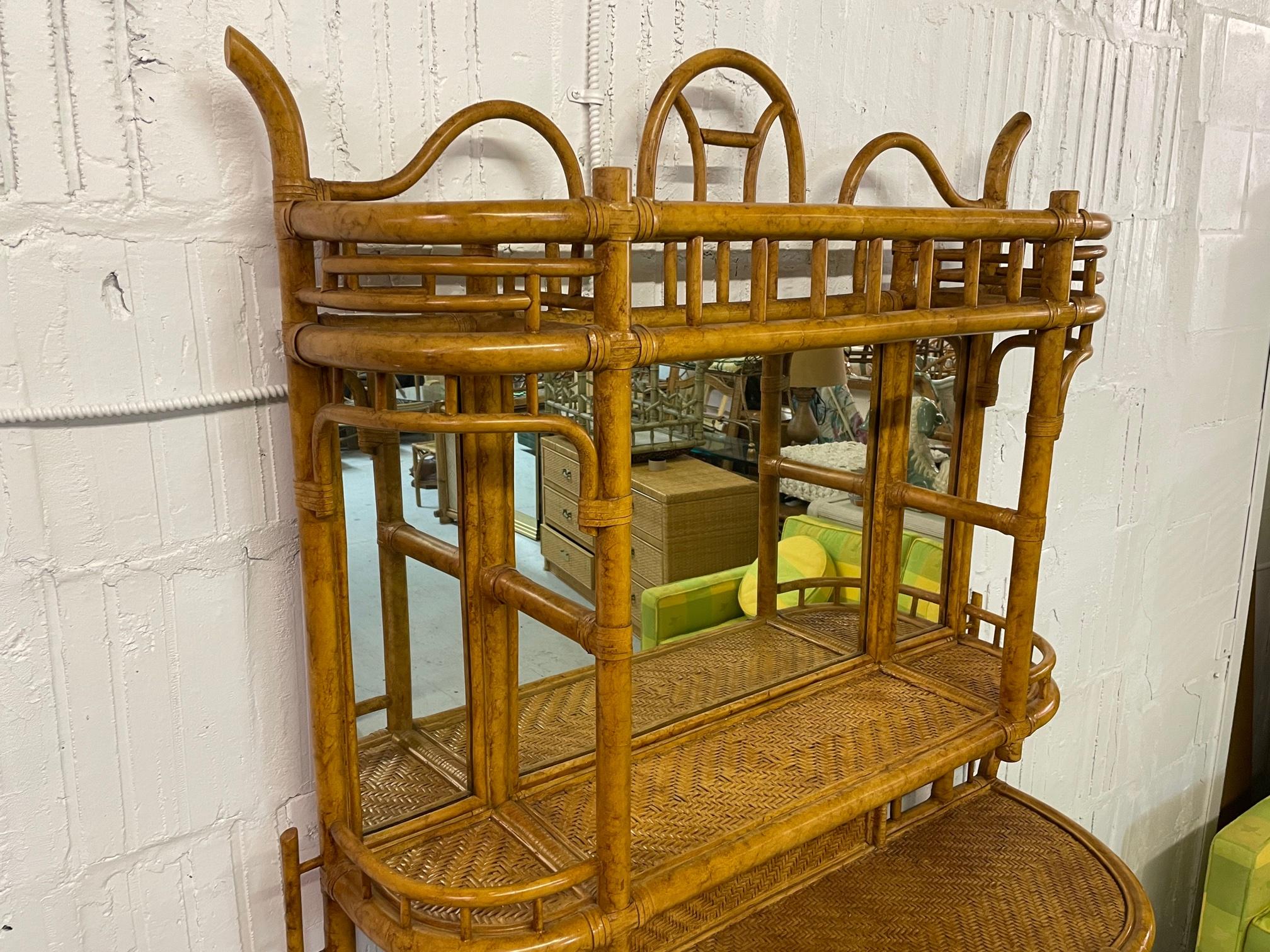 Large rattan étagère/bookcase features woven wicker shelving and a mirrored back. Maitland Smith label is no longer present, but has been verified as Maitland Smith. Back shows a Lexington Furniture label, a dealer who carries the Maitland Smith
