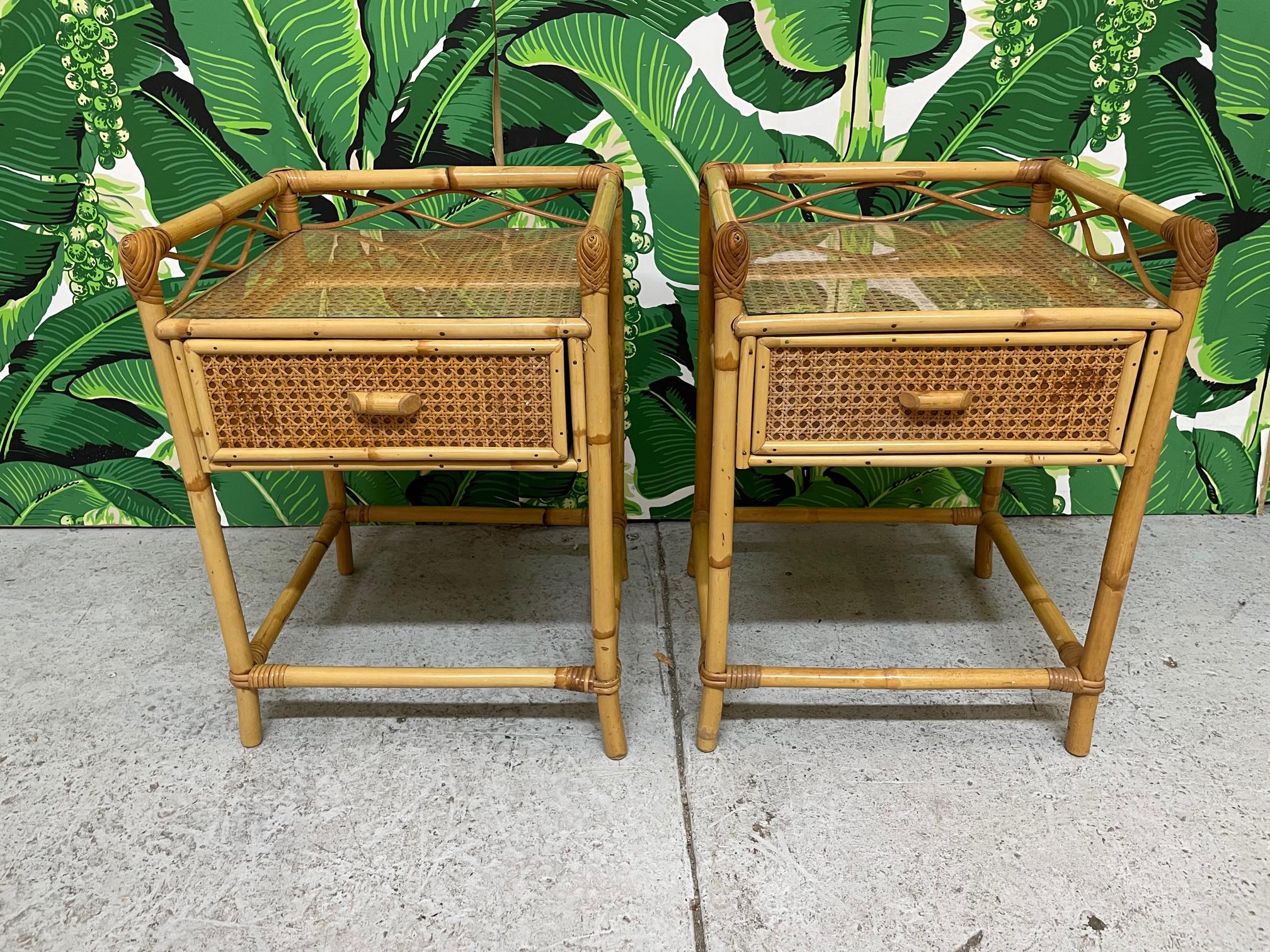 Pair of vintage nightstands feature rattan construction and woven wicker veneer. Removable glass tops. Very good condition with minor imperfections consistent with age. We also have a matching mirror, dresser, and vanity.
Shipping to most of the