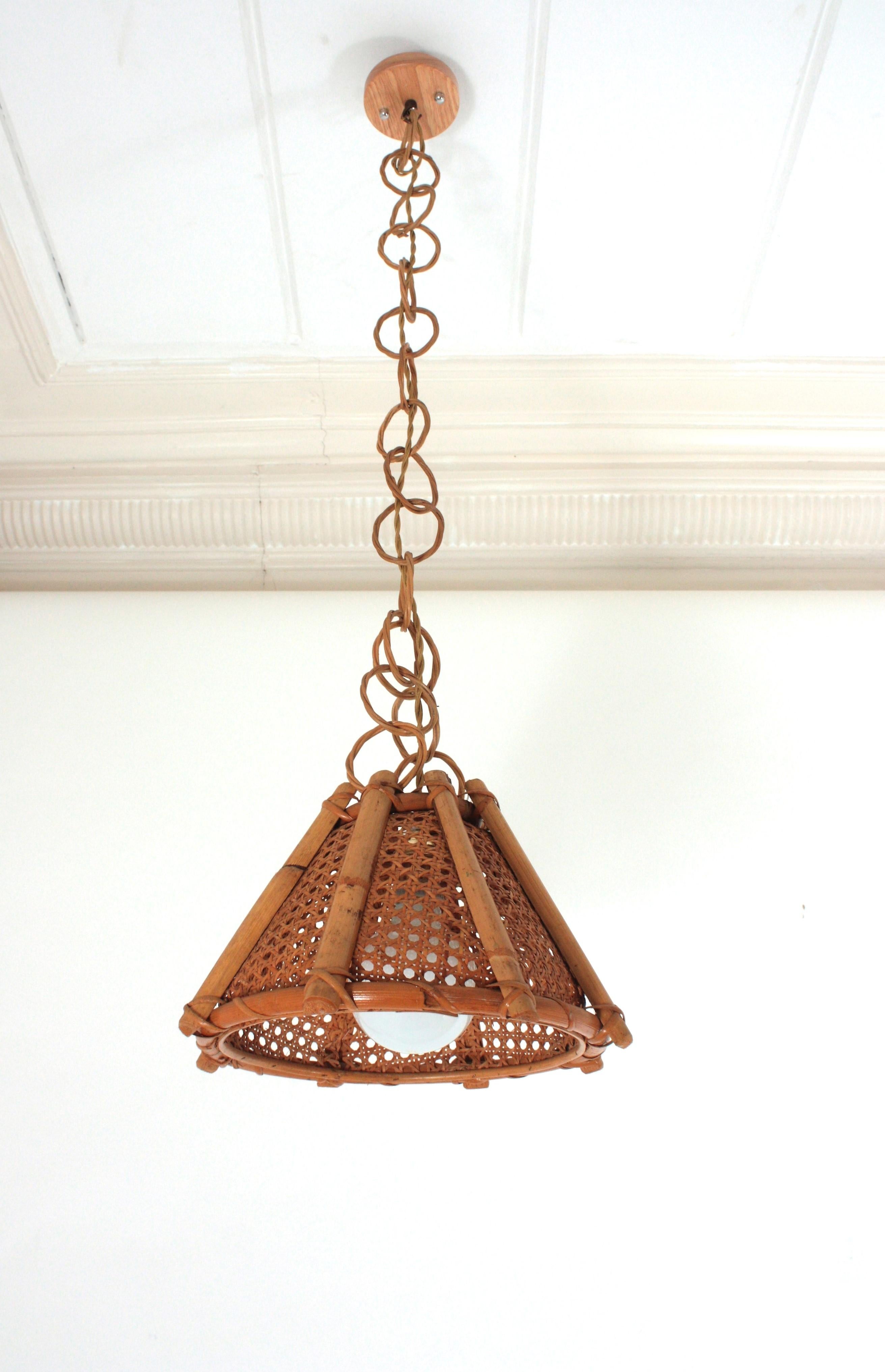 Mid-Century Modern geflochtener Draht und Rattan konisch geformte Laterne oder hängende Deckenlampe. Italien, 1960er Jahre. 
Der geflochtene Weidenschirm dieser Lampe wird durch vertikale Rattanstäbe und charmante Details am unteren Teil