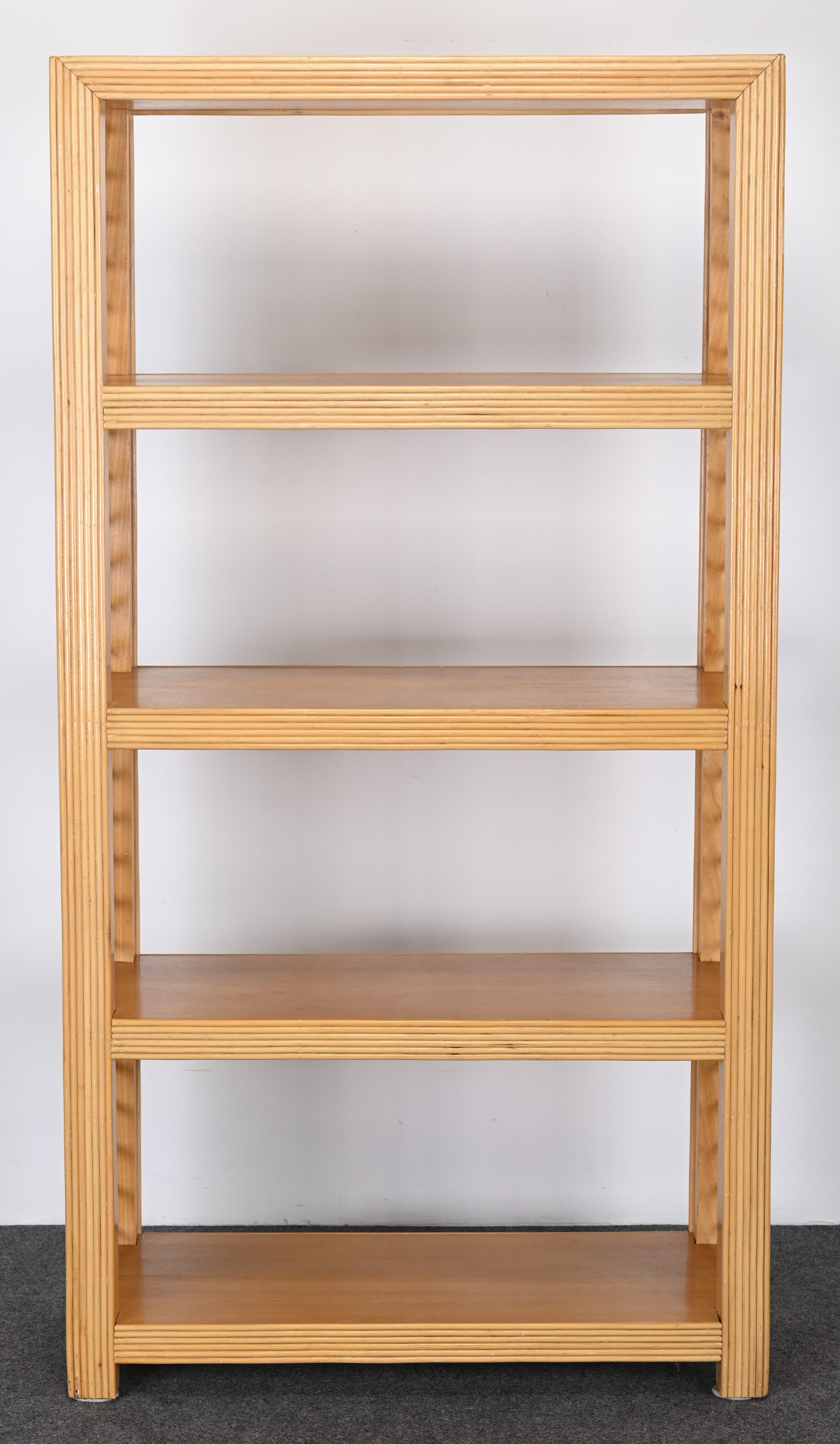 An organic modern rattan and wood freestanding shelving unit or bookcase. This beautiful shelf is in the manner of McGuire, however, there are no labels or markings. Very fine details with hand-wrapped windings and reeded rattan accents. This shelf