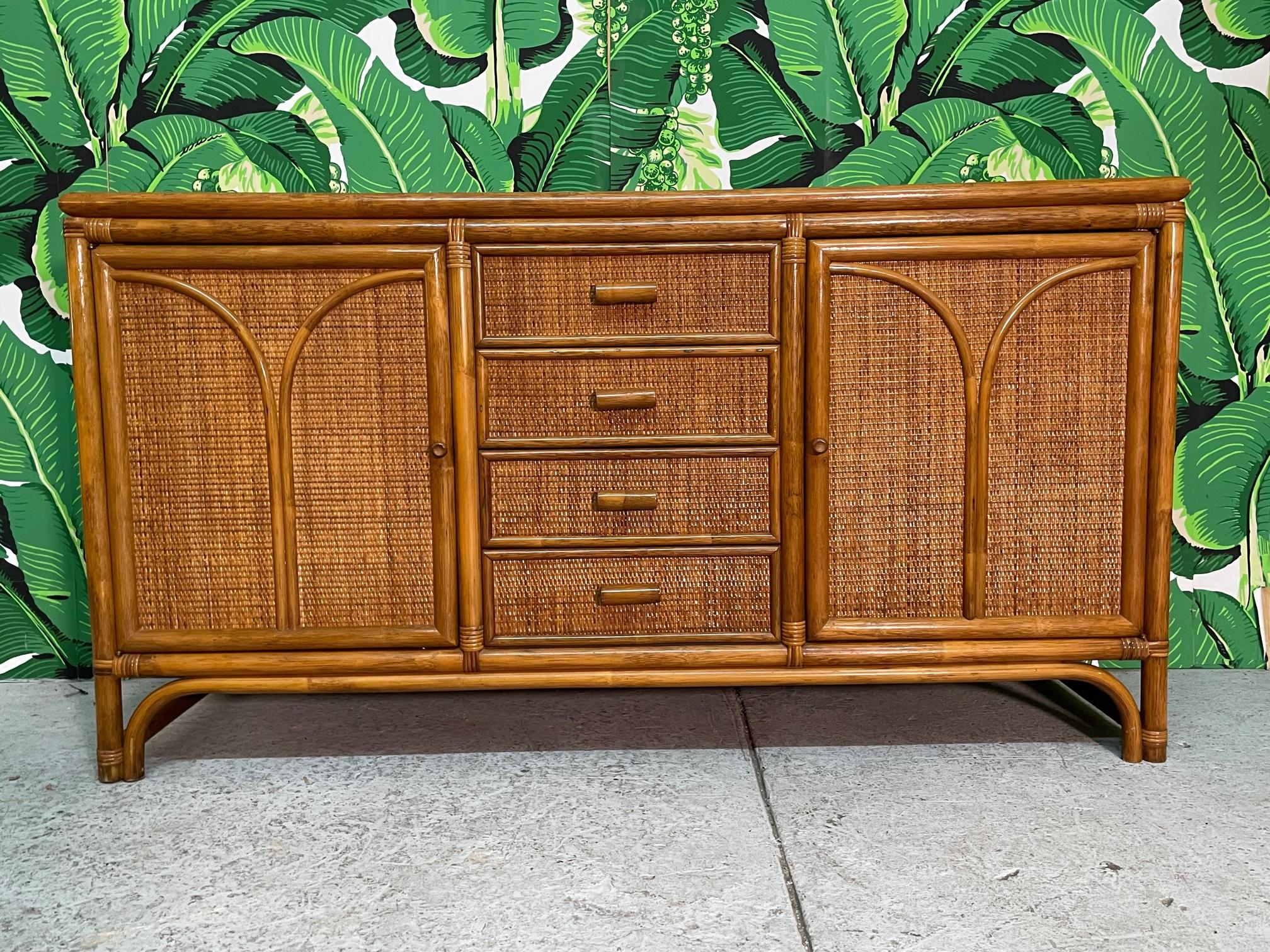 Rattan buffet or credenza features a full veneer of woven wicker and pencil reed detailing. Recently restored and in excellent condition. We also have a matching pair of etageres available.
 