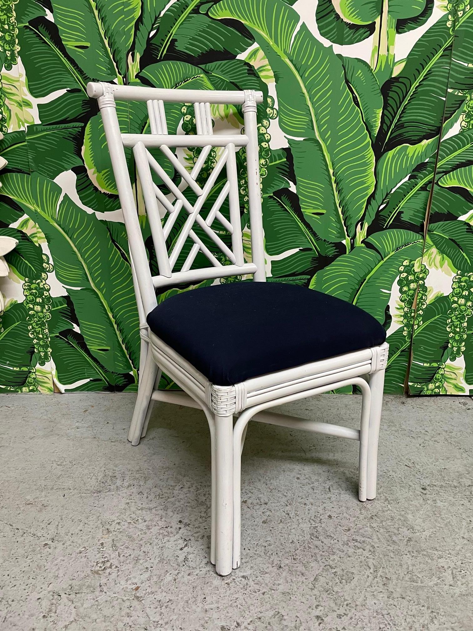 Set of ten vintage rattan dining chairs in Asian chinoiserie style. Six chairs have white upholstery and four have dark blue. Good condition with minor imperfections consistent with age.